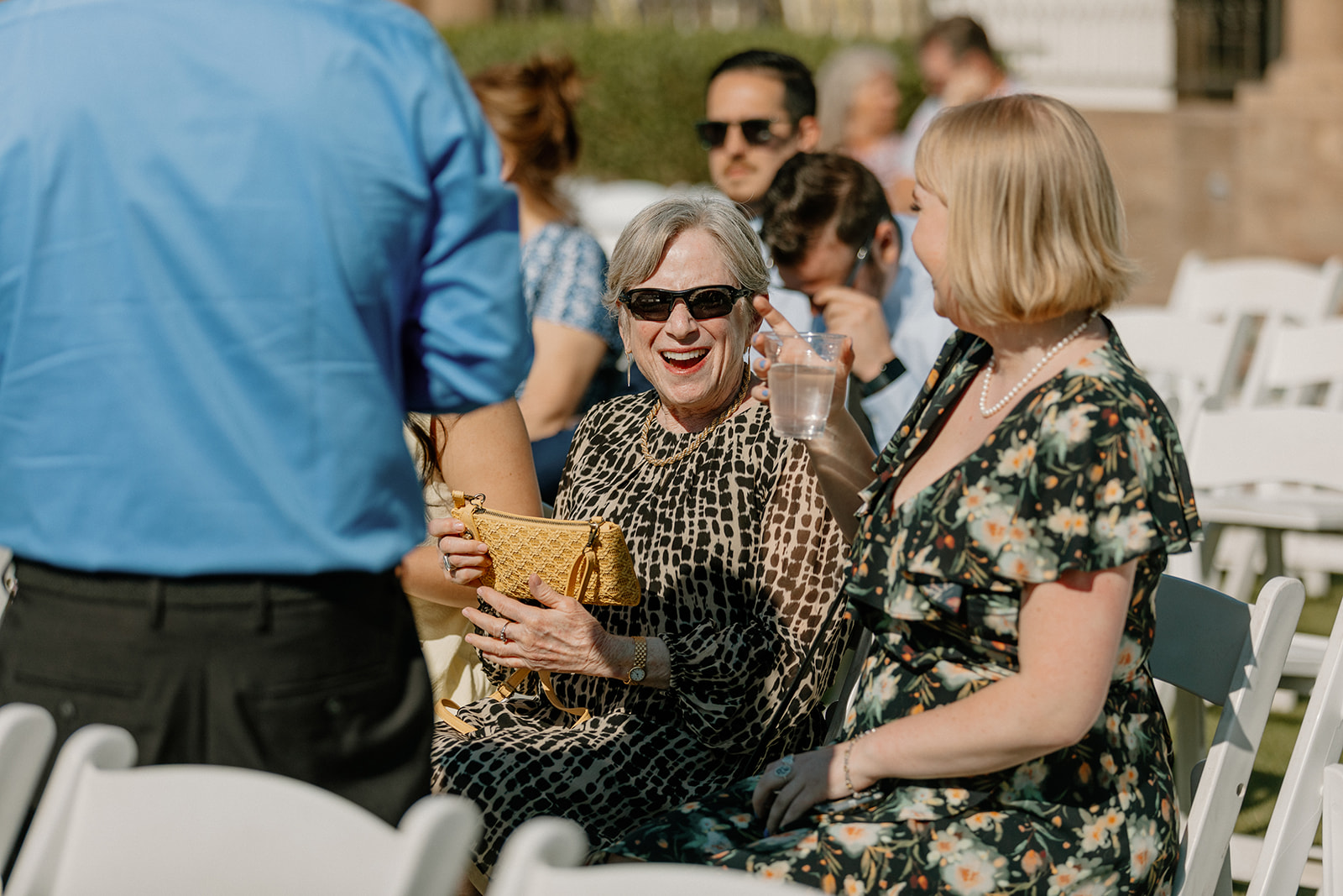 Laughter and chatter fill the front rows as wedding guests mingle and sip water before the ceremony at Blackstone Country Club.