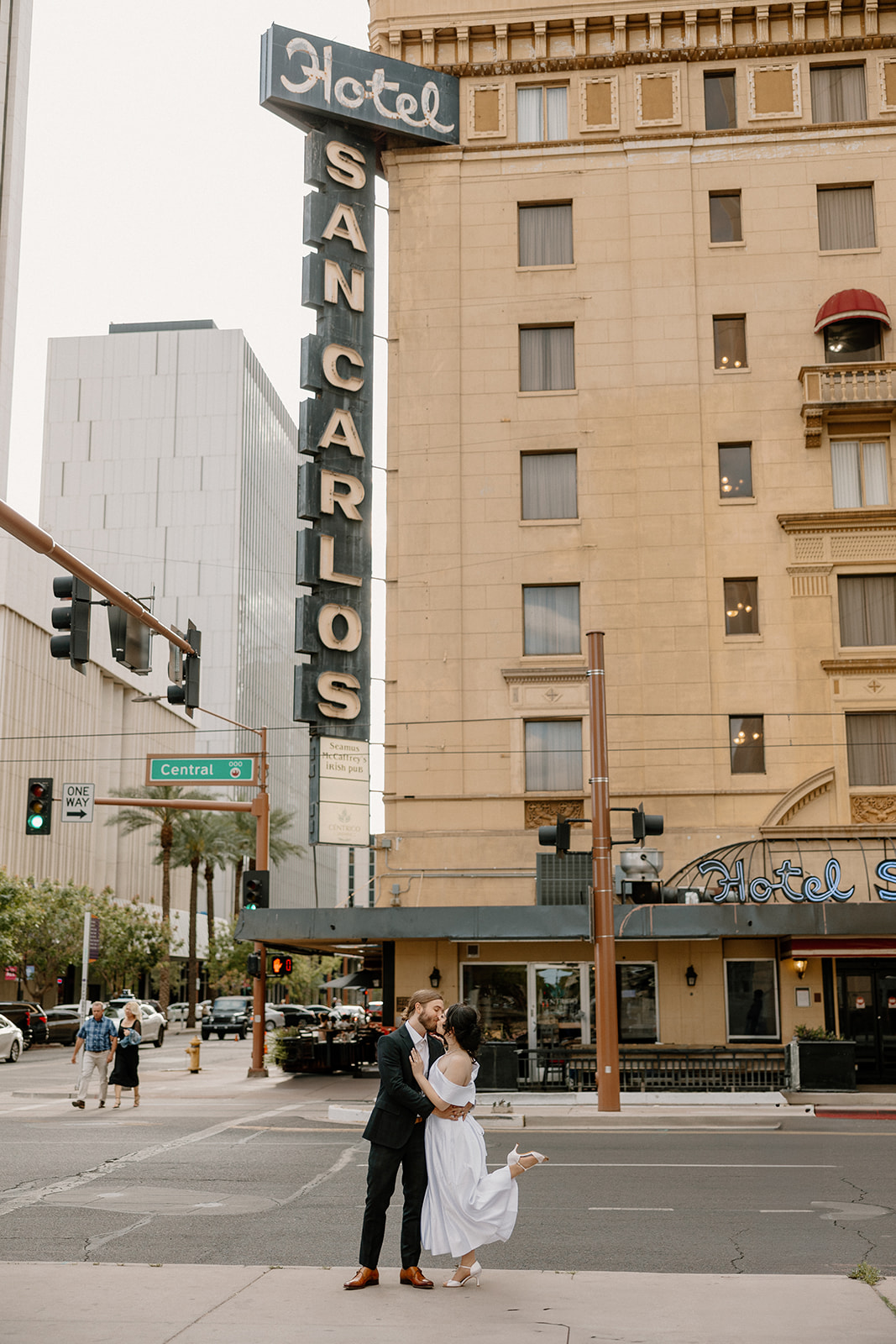 Couple dancing in the middle of a downtown intersection with the vintage Hotel San Carlos sign behind them.
