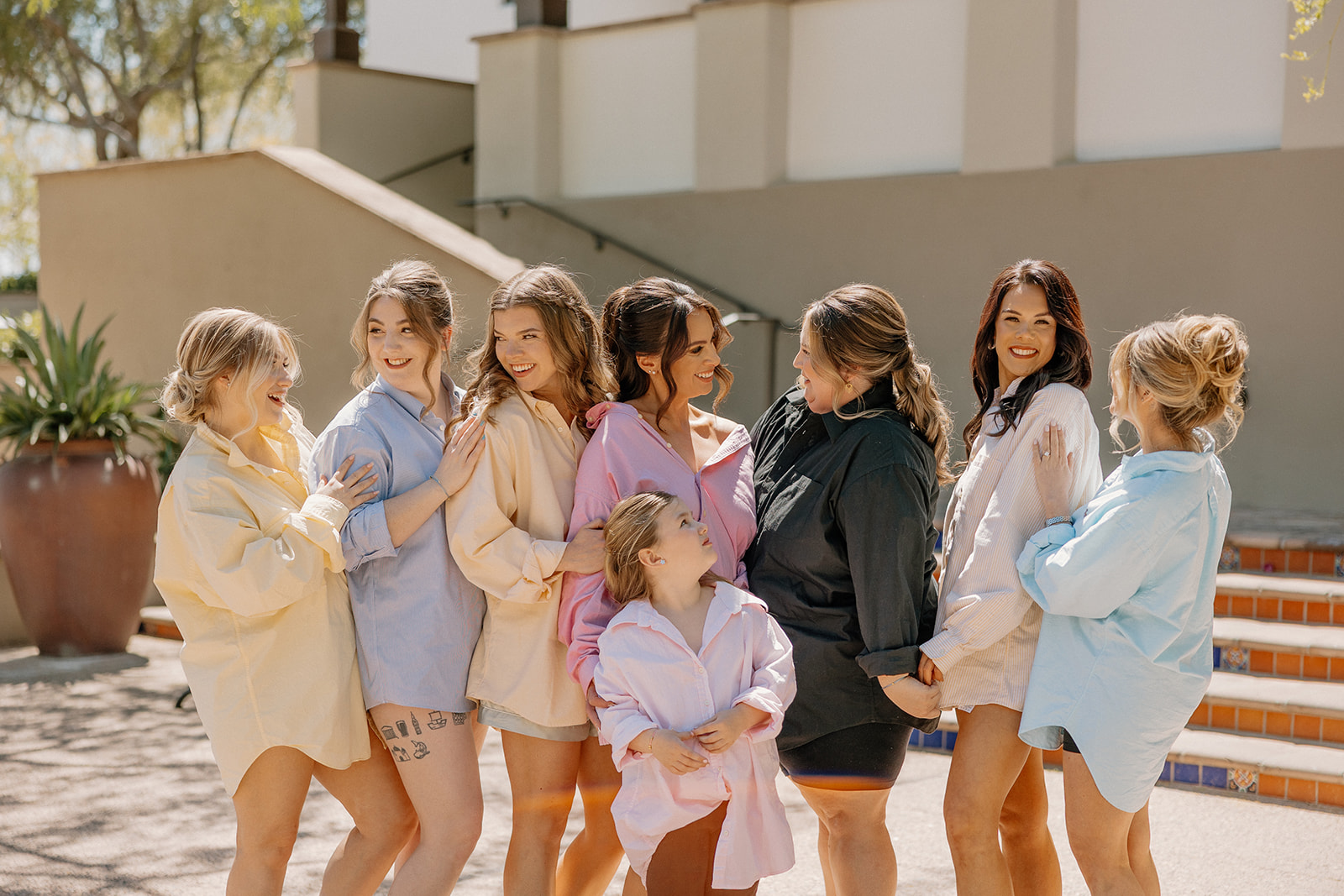 The bride and her bridal crew pose in playful, oversized button-downs before getting ready at Blackstone Country Club.