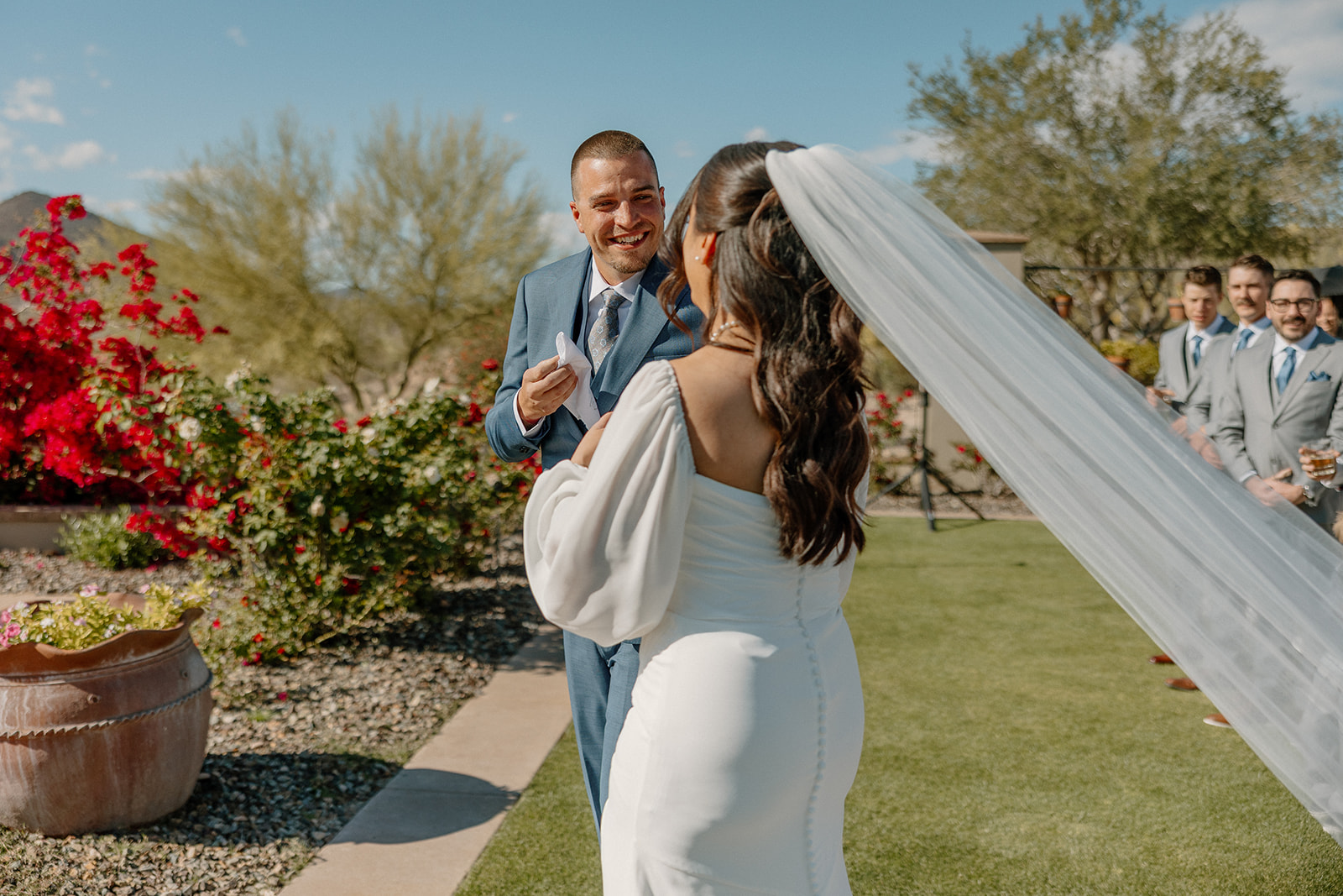 The groom flashes a huge smile as he and the bride walk back up the aisle at Blackstone Country Club, her veil flowing in the breeze behind her.