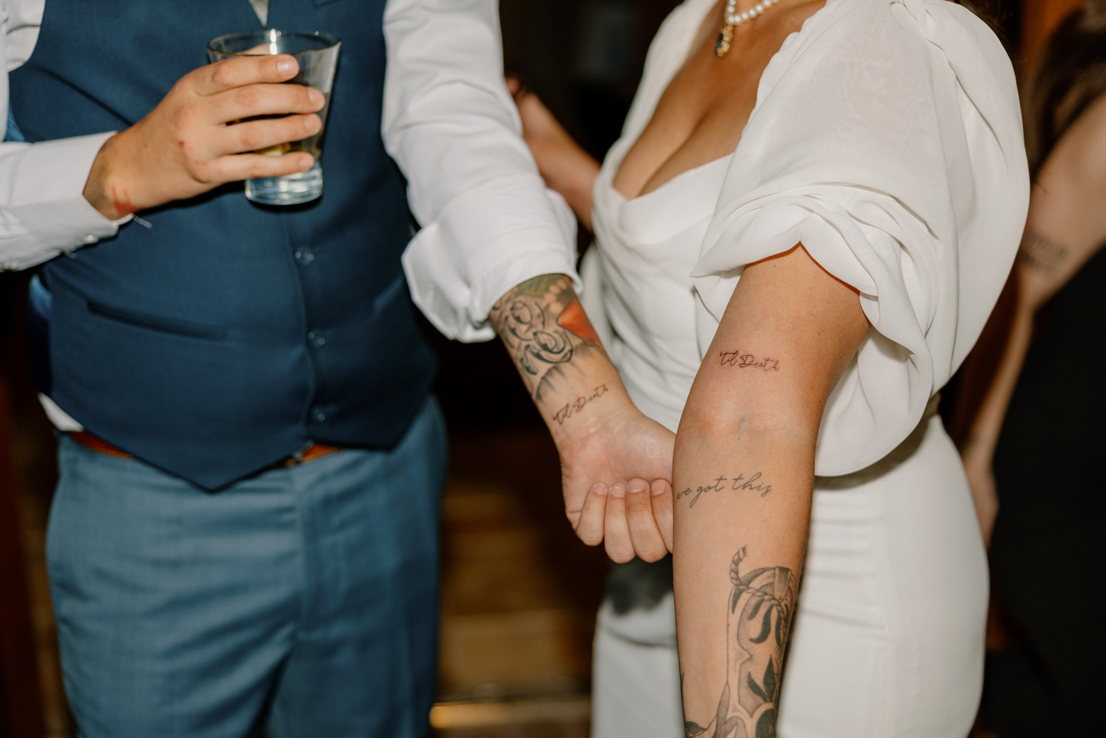The bride and groom show off fresh matching tattoos, part of a surprise reception experience.