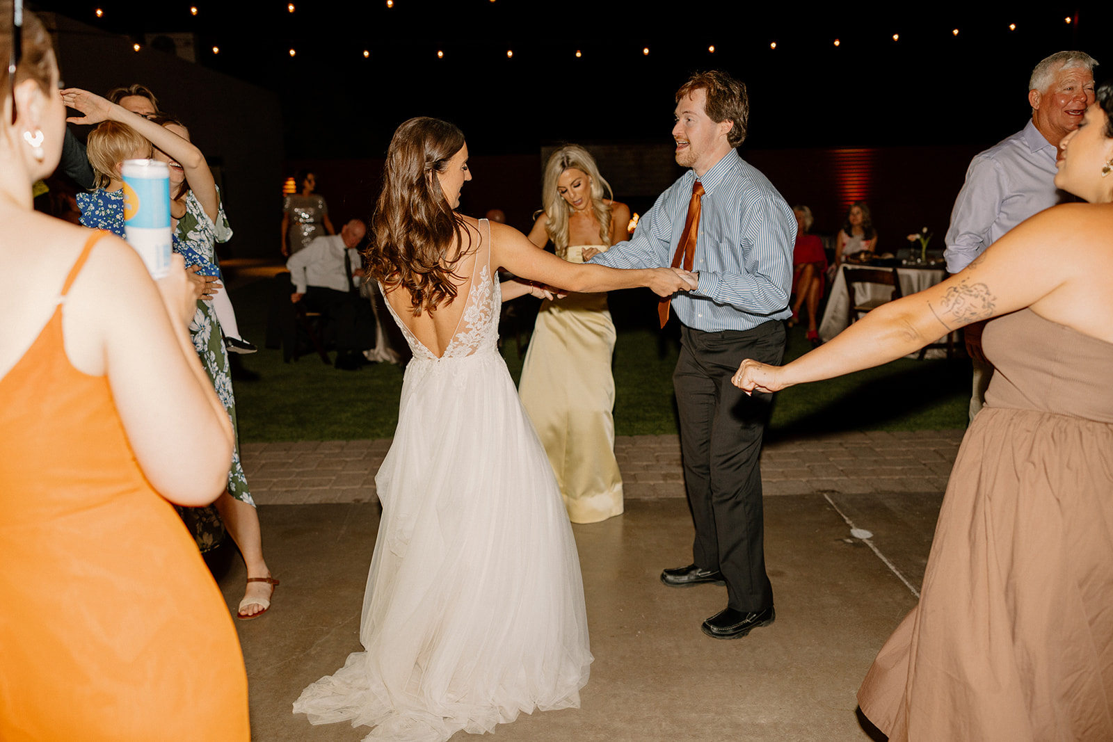 Bride dancing barefoot under the stars at The Paseo, spinning with guests as the music plays on.