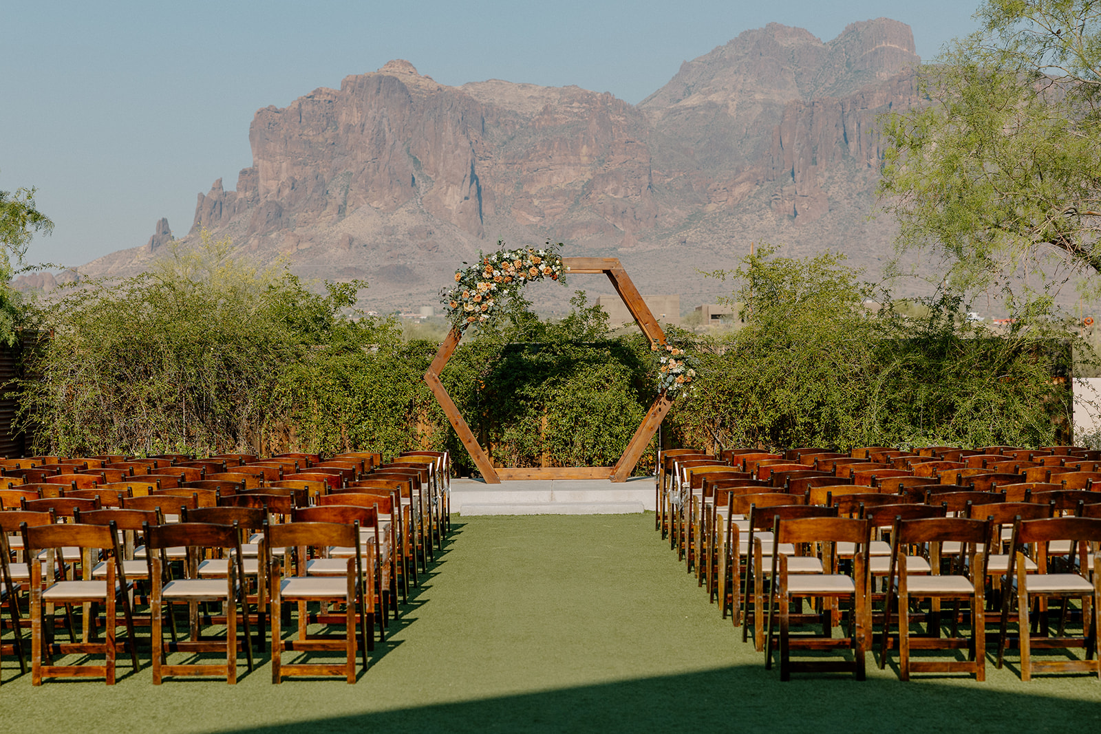 Wide shot of the ceremony setup at The Paseo with rows of wooden chairs and a mountain view that stuns every time.