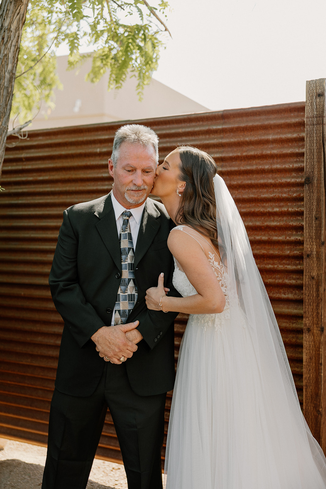 Bride kissing her dad on the cheek during a sweet moment before the ceremony at The Paseo.