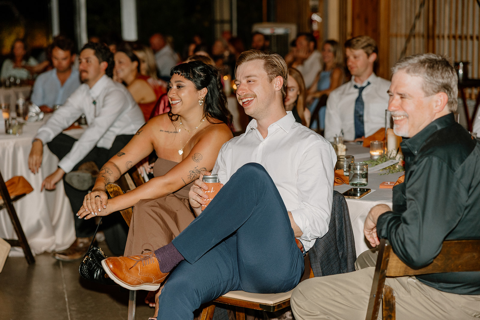 Guests laughing and enjoying speeches during the wedding reception at The Paseo.