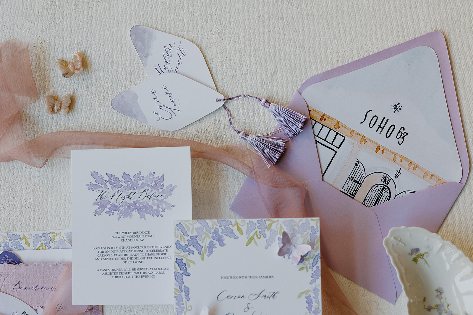 Wedding invitation suite with lilac accents, butterfly details, and a custom SoHo63 venue illustration.