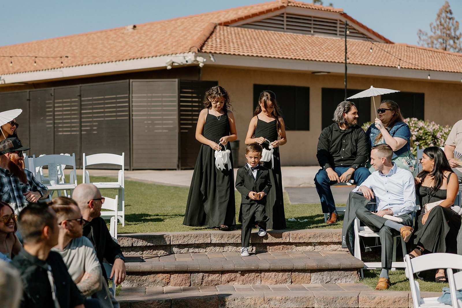 Two flower girls and a ring bearer make their way down the steps during the wedding processional.