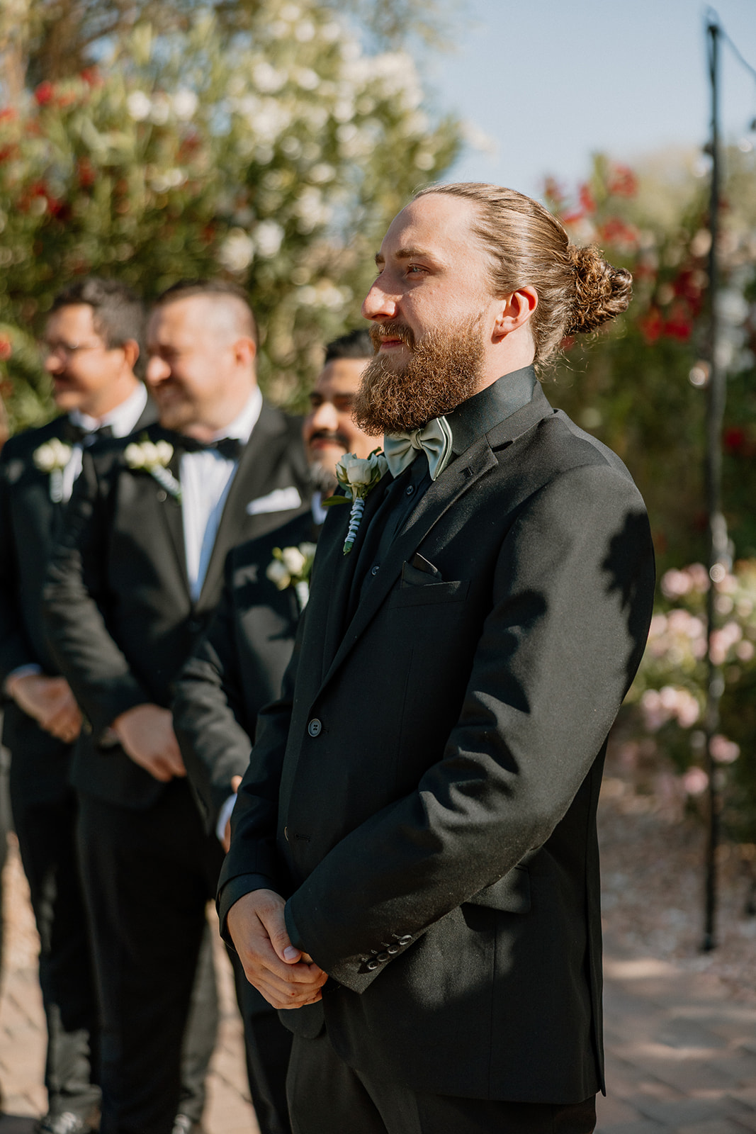 The groom beams with anticipation while watching his bride walk down the aisle at an Arizona wedding venue.