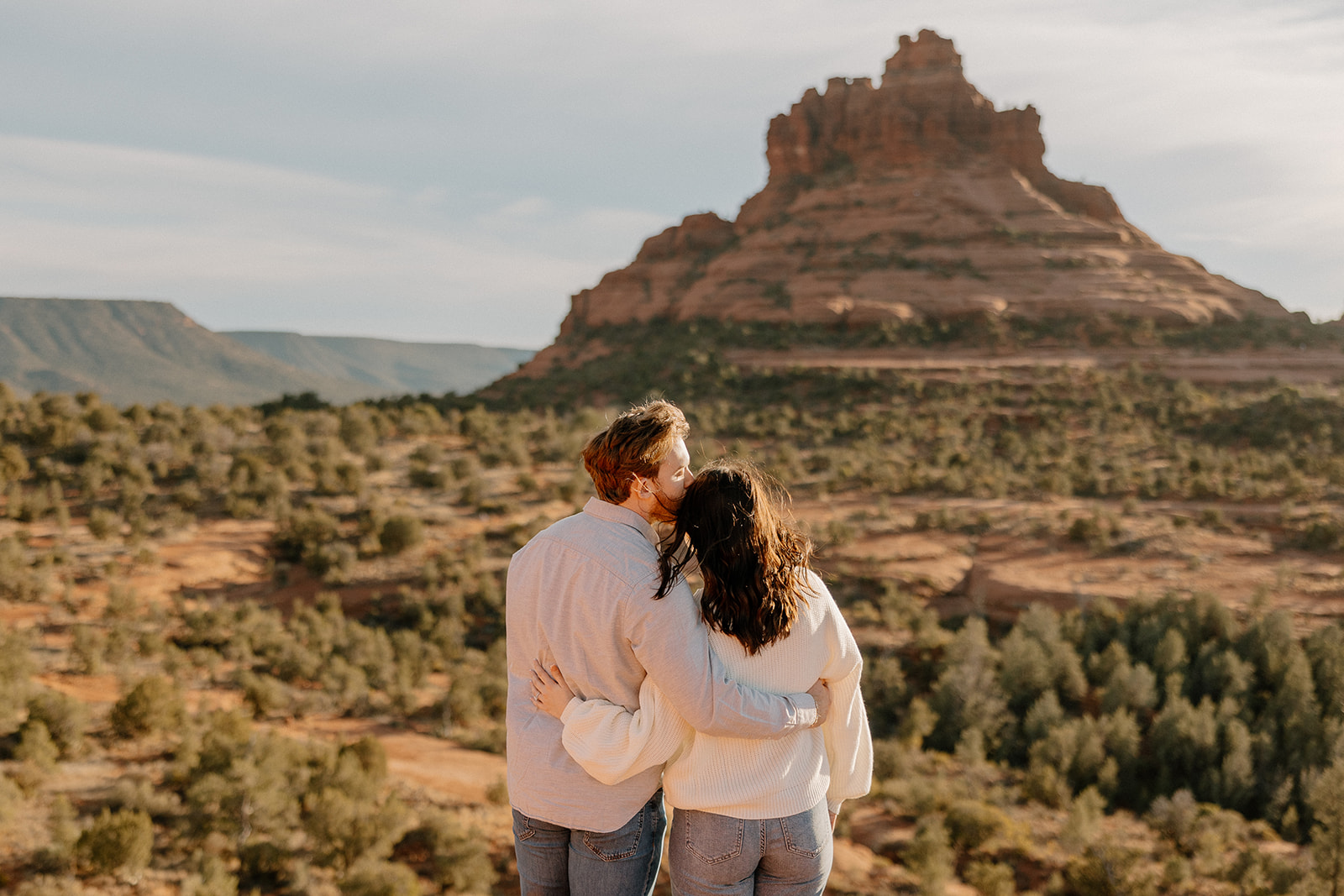 Engaged couple embracing while looking at the view before Sedona elopement