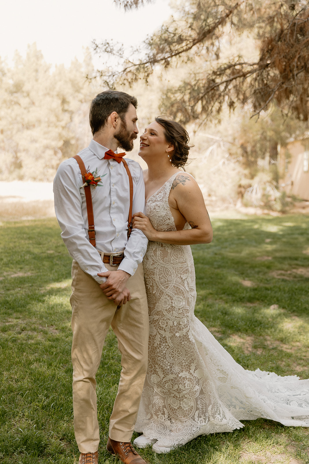 Bride holds groom's arm and looks up at him adoringly after wedding at Schnepf Farms. 