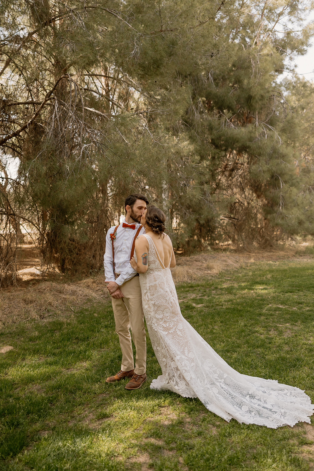 Groom turns to see his bride during their first look in a forested clearing, both smiling at Schnepf Farms.
