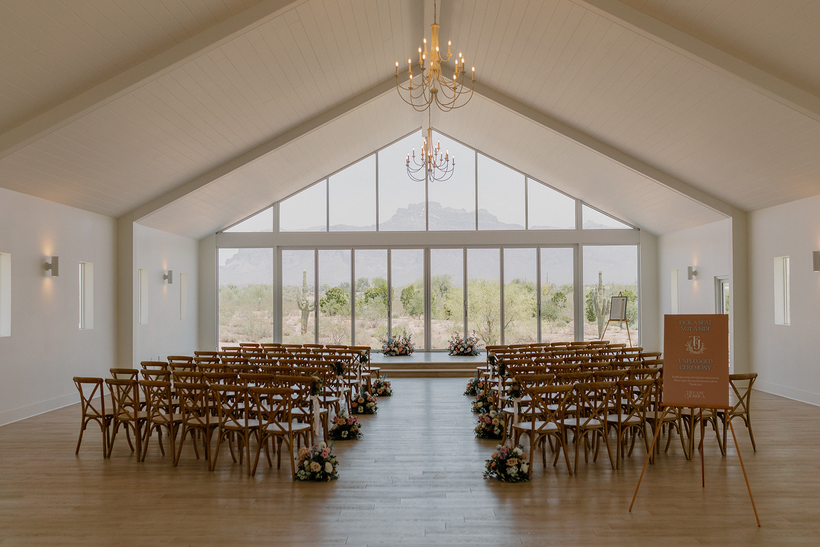 Wide view of ceremony space with wooden chairs and breathtaking view of desert landscape. 