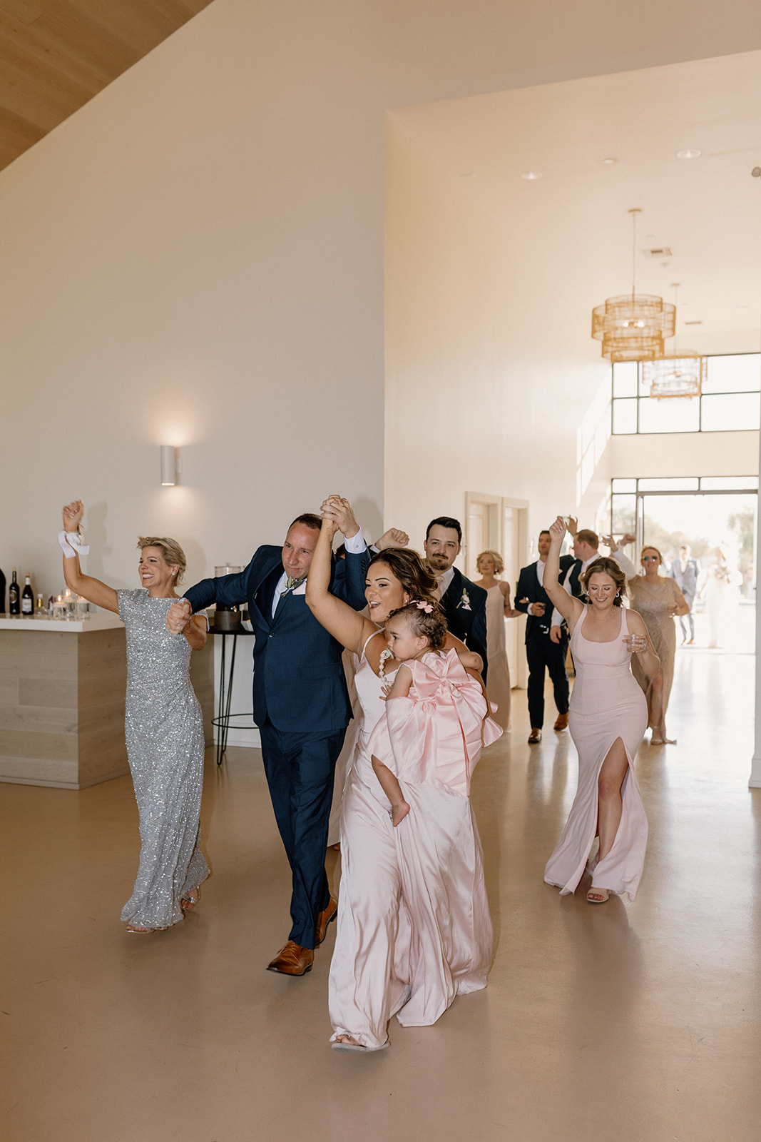 Wedding party dances into the reception getting ready to celebrate together. 