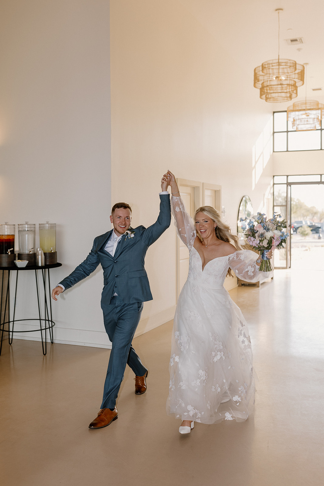 Bride and groom make their grand entrance lifting hands in the air during their welcome to the reception. 