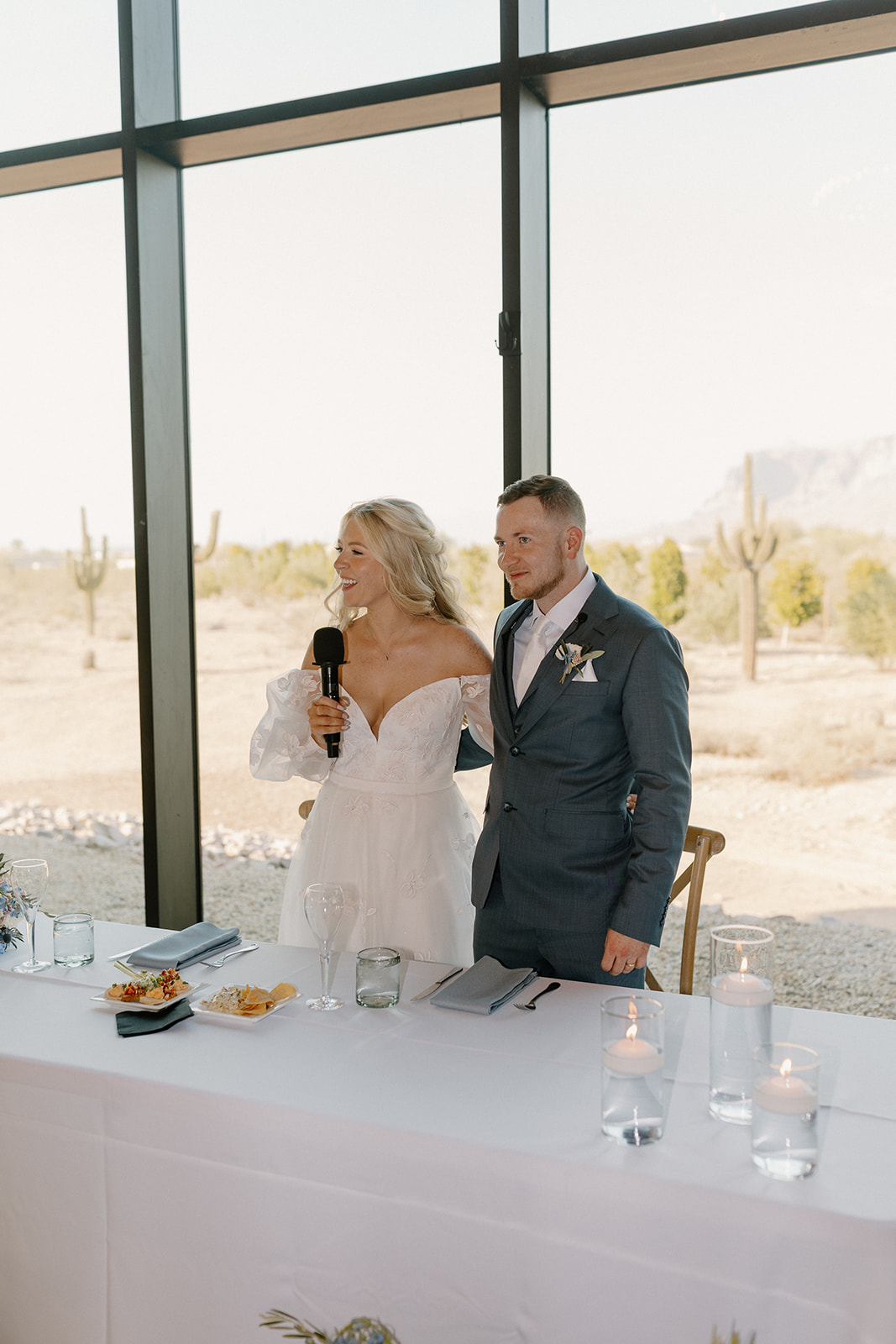Bride holds microphone to greet guests during Desert View wedding reception. 