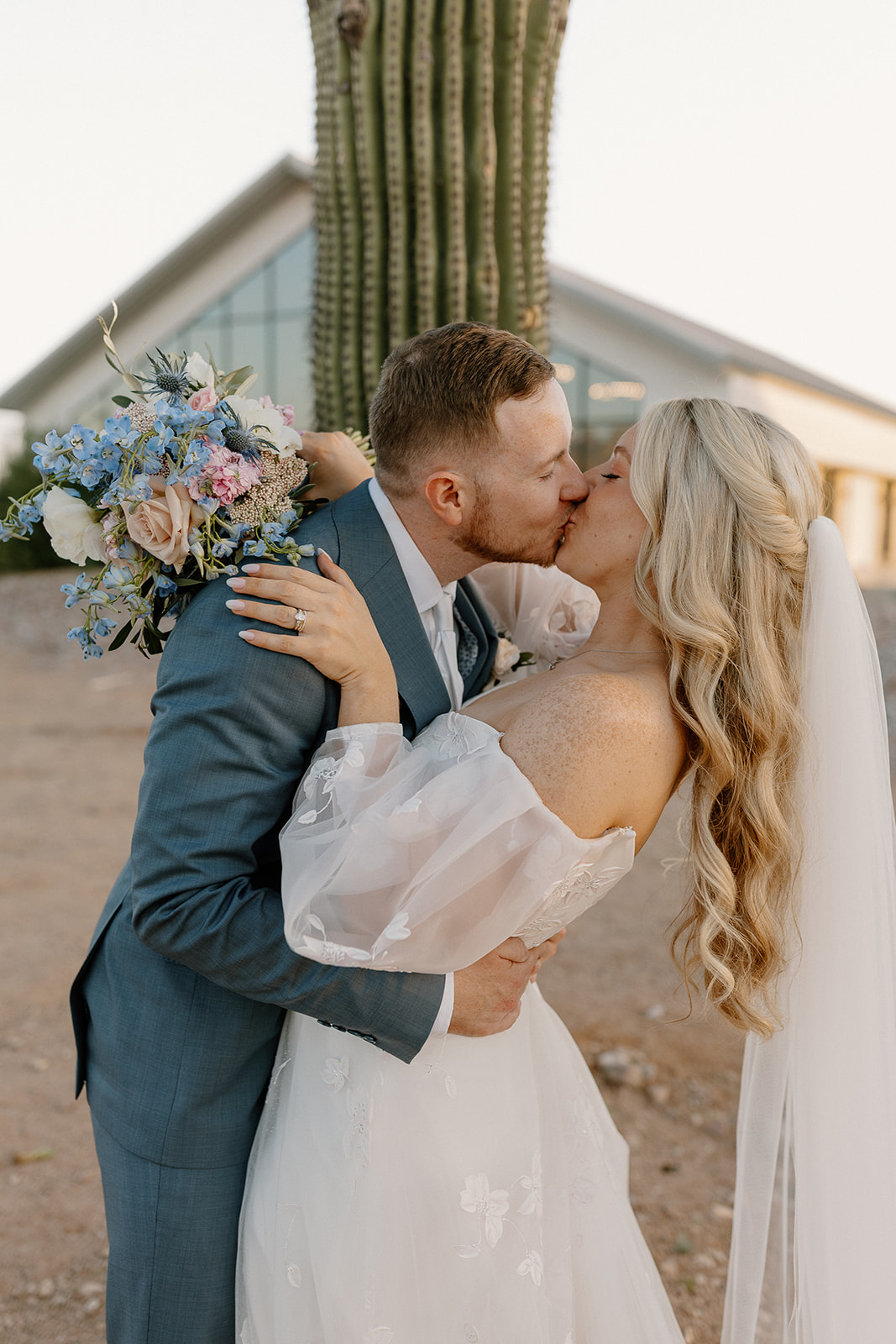 Close up of bride and groom kissing in front of cactus after Desert View wedding