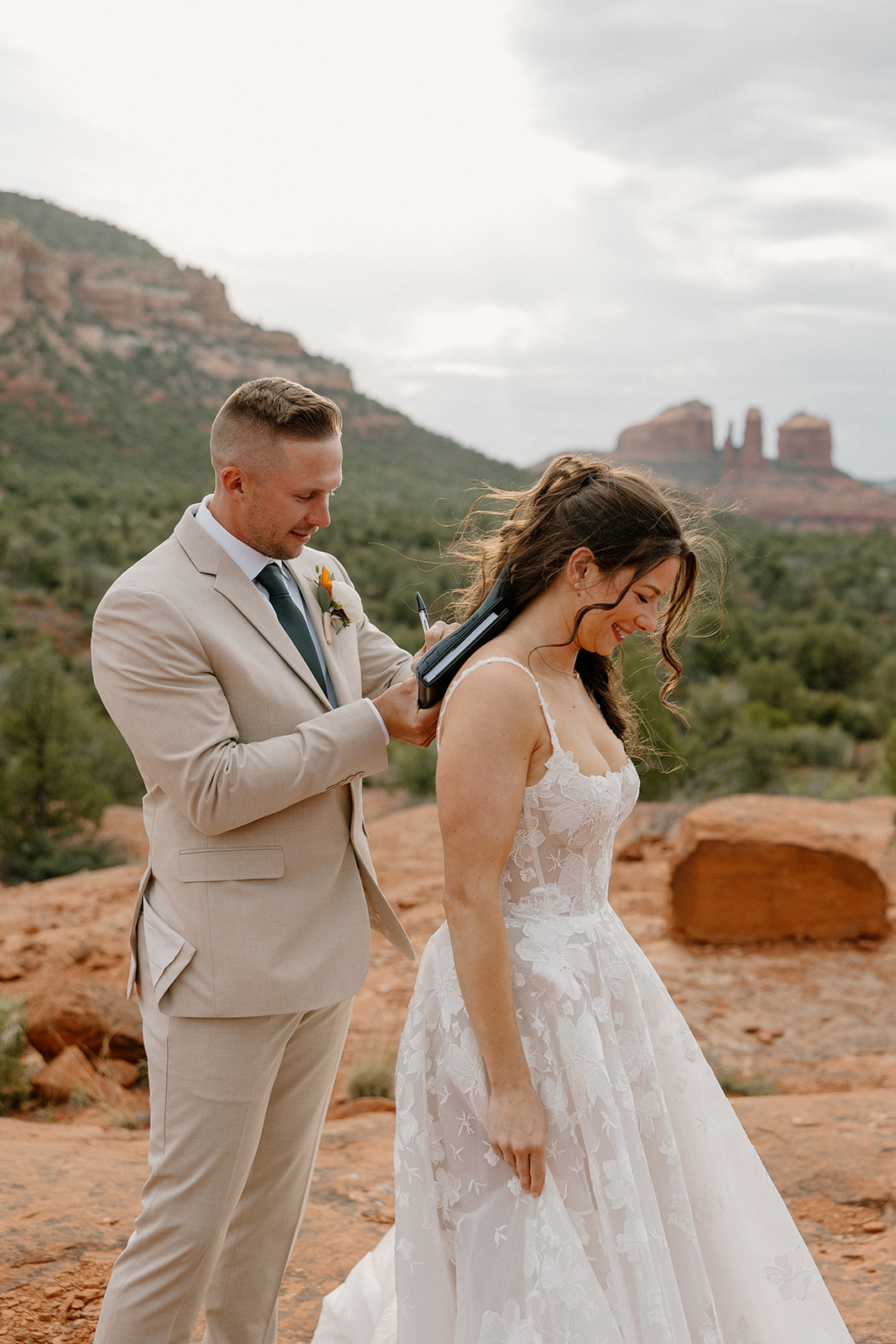 Groom signs marriage license using the bride's back after their Bell Rock Sedona elopement. 