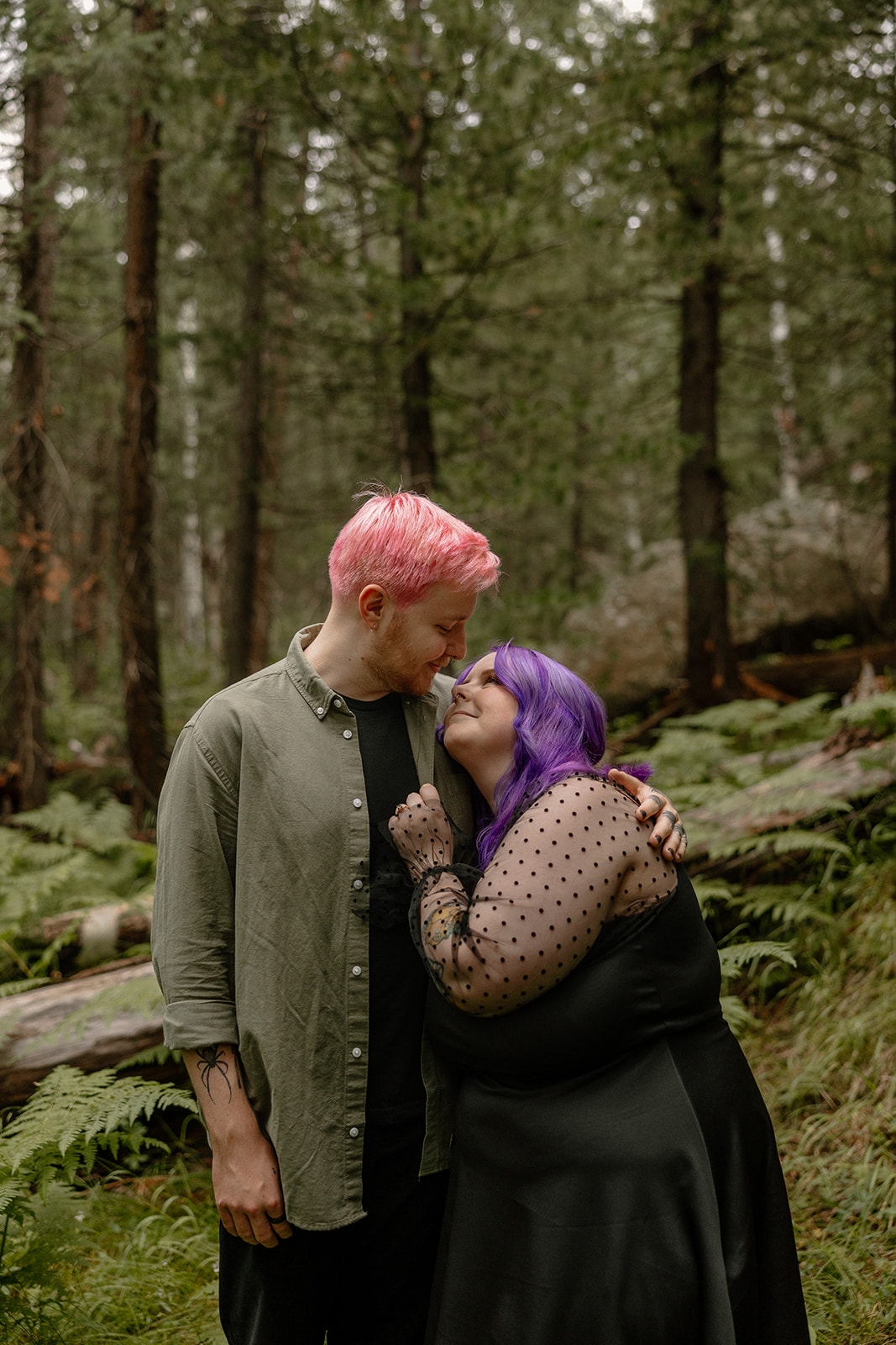 Close-up moment of a couple sharing a forehead kiss in the forest, their connection radiating through the stillness of the woods.