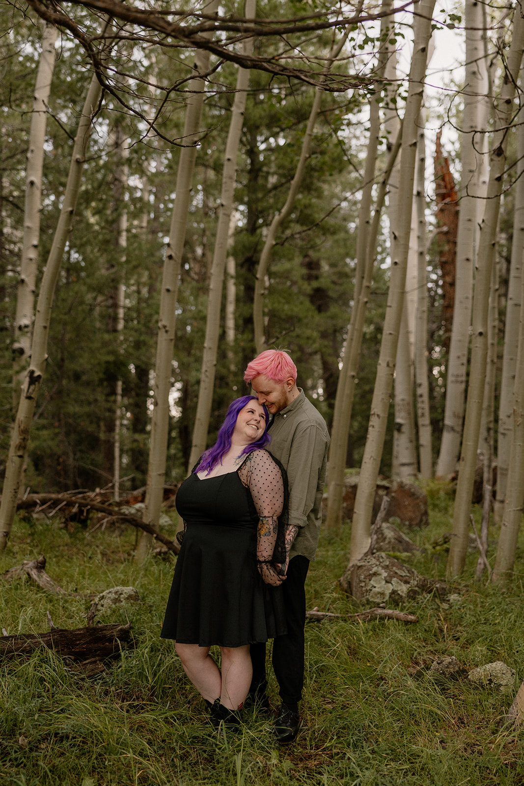 Cozy pose in a grove of aspens, with the couple gently leaning into each other—classic but not cliché, one of our fave engagement photo ideas.