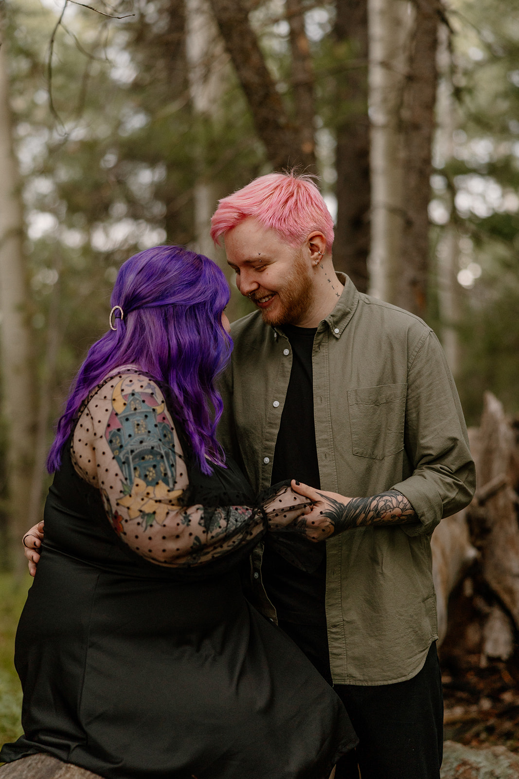 They lean in close with matching smiles, holding hands and looking fully smitten—proof that cozy forest spots make dreamy engagement photo ideas.