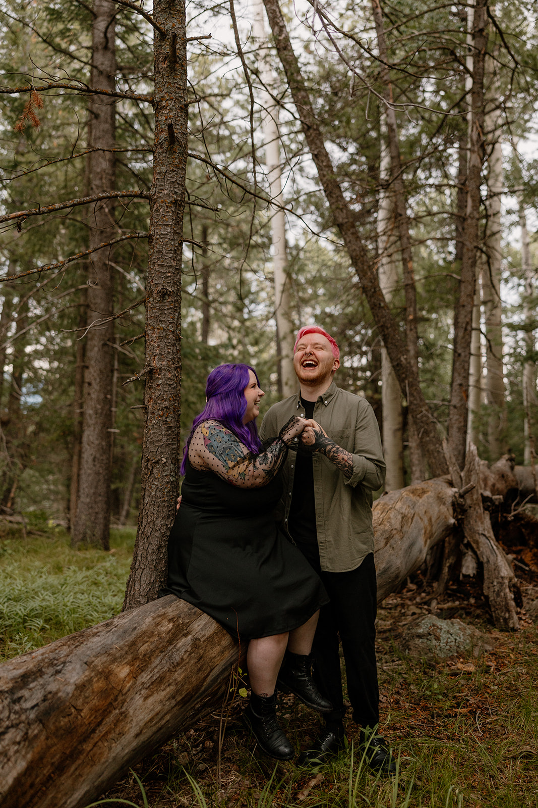 Joyful laughter as the couple stands close together on a log, radiating playful energy—one of our favorite engagement photo ideas for outdoorsy duos.