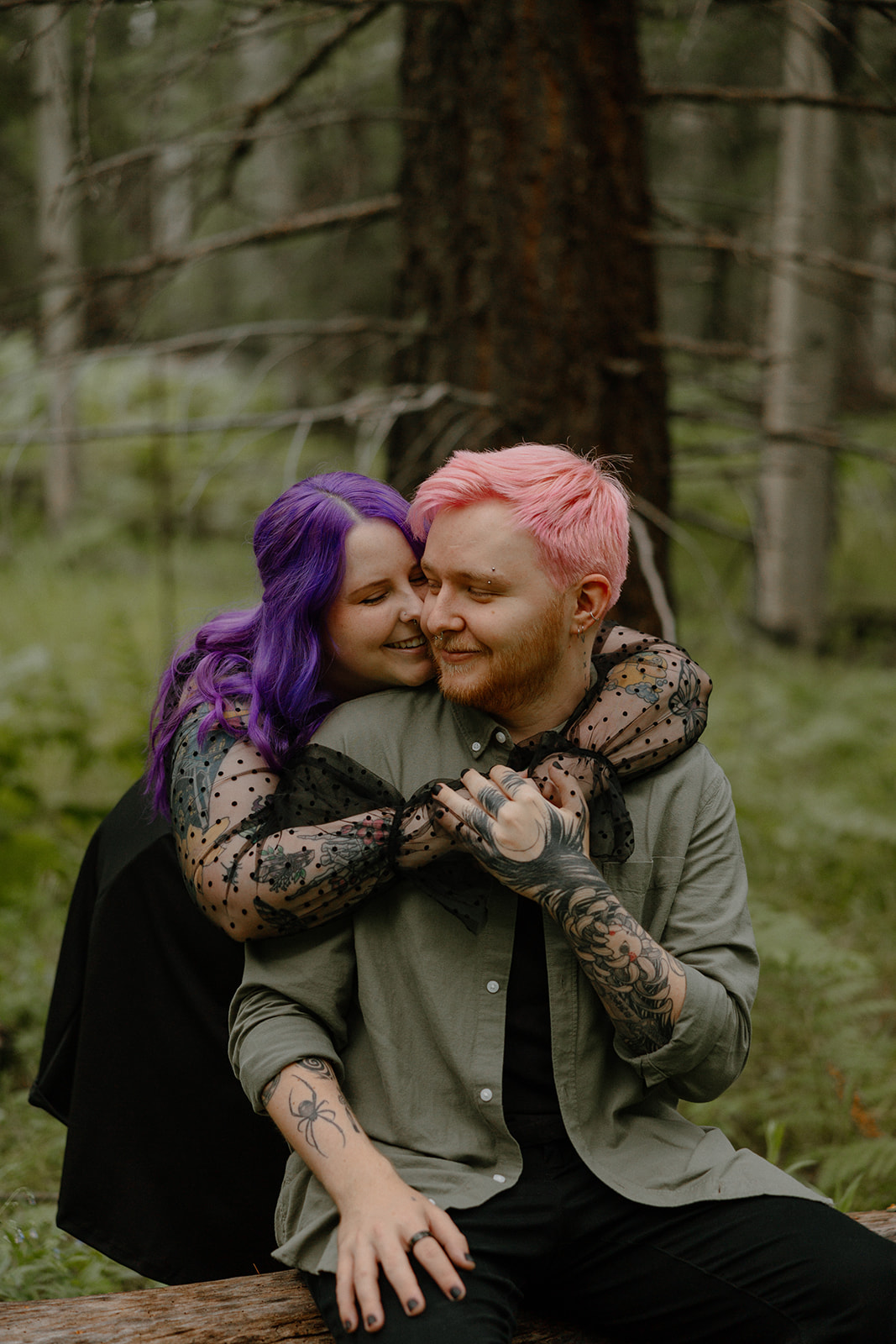 Joyful embrace from behind as a woman wraps her arms around her partner, both smiling in a quiet forest moment.