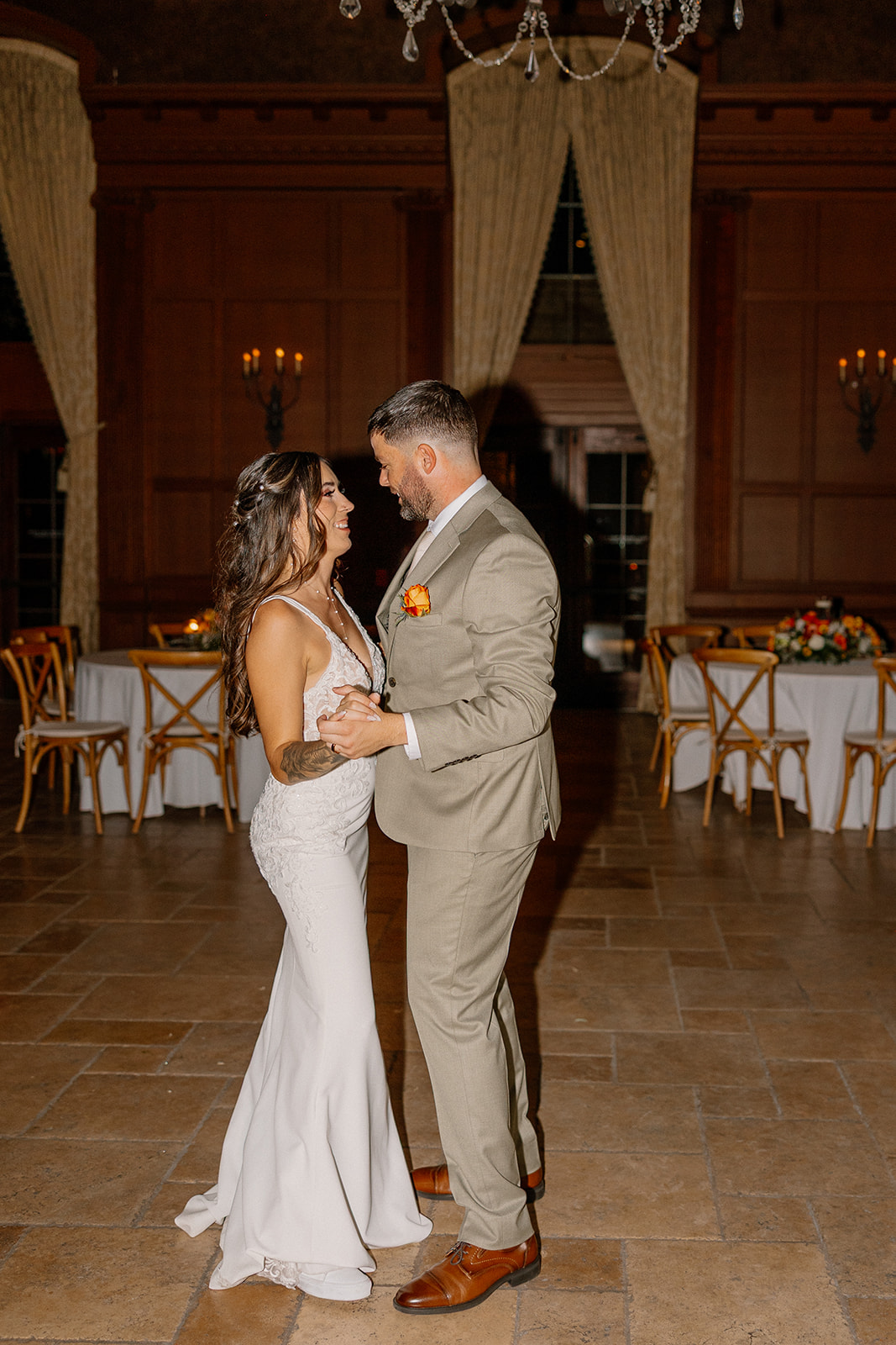 A quiet, joyful spin on the reception floor as the couple shares their first dance surrounded by cozy wood tones and candlelit tables.