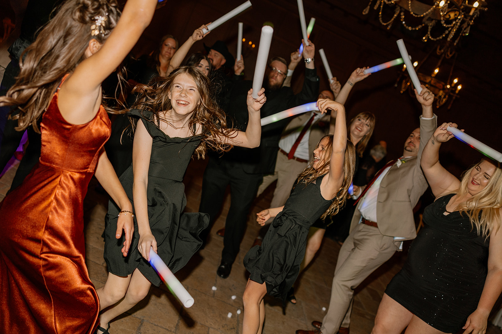 Everyone—from the flower girls to the grown-ups—is all-in on the celebration, waving neon sticks and dancing under the chandeliers.