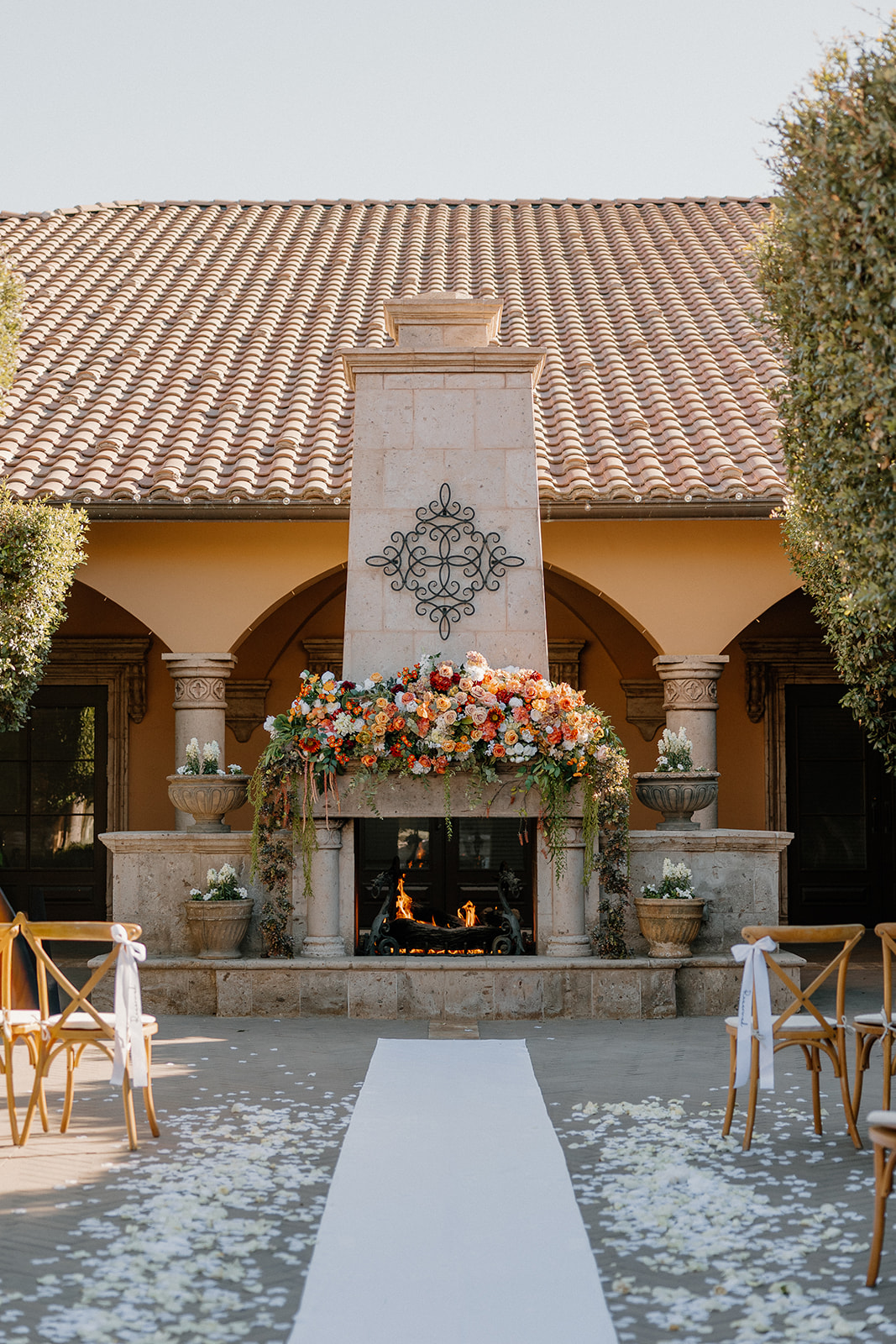 Courtyard fireplace decorated with lush florals, ready for the wedding ceremony at a Gilbert wedding venue.