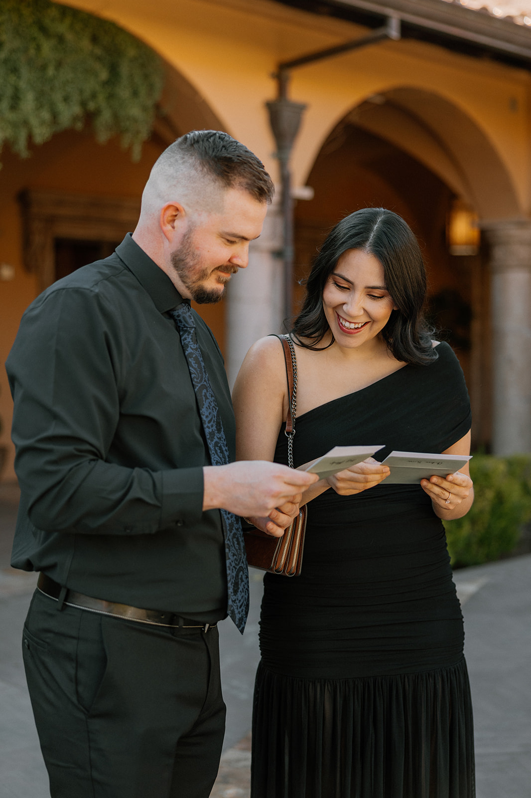 Guests reading personal handwritten notes from the couple outside the ceremony space.