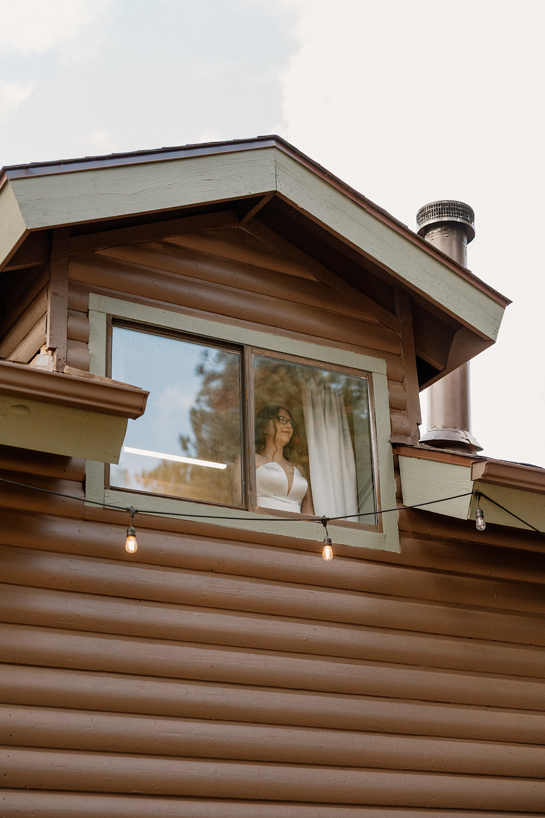 Overhead shot of bride walking up a wooden staircase, her veil trailing behind her in the golden light.
