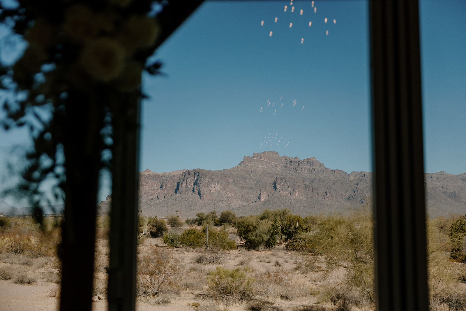 Superstition Mountains framed perfectly by the venue’s ceremony arch window — location goals for your wedding planning guide.