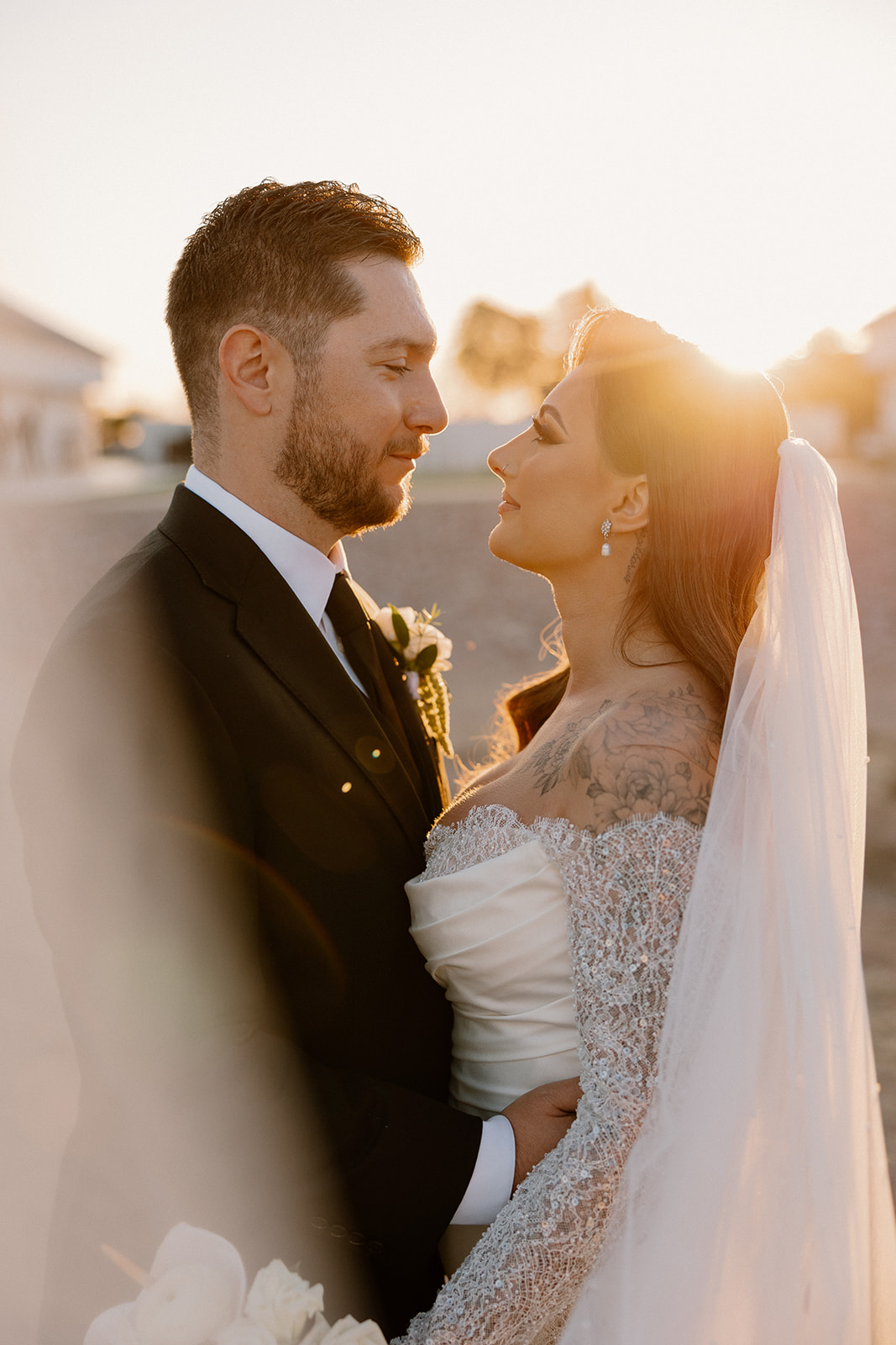 Sunset portrait of the couple sharing a quiet moment, light flaring around them.