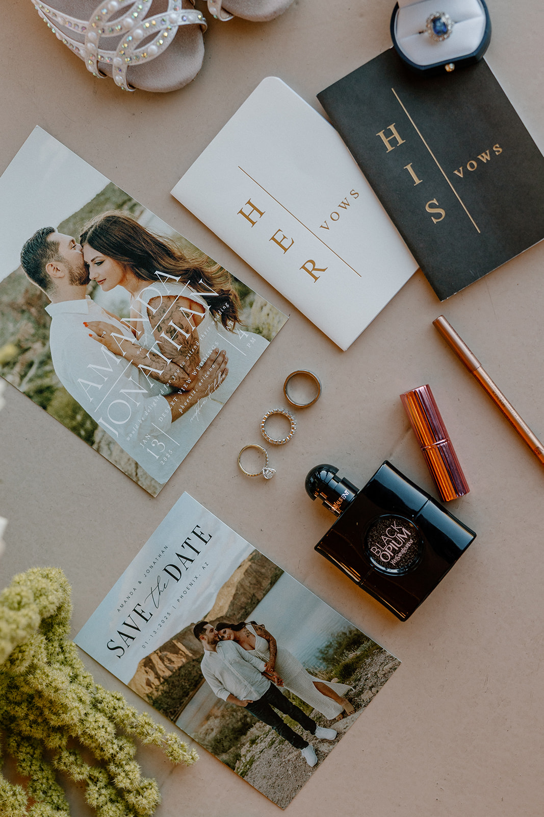 Elegant wedding flat lay with vow books, rings, perfume, and save-the-dates — a must-have visual in your wedding planning guide.