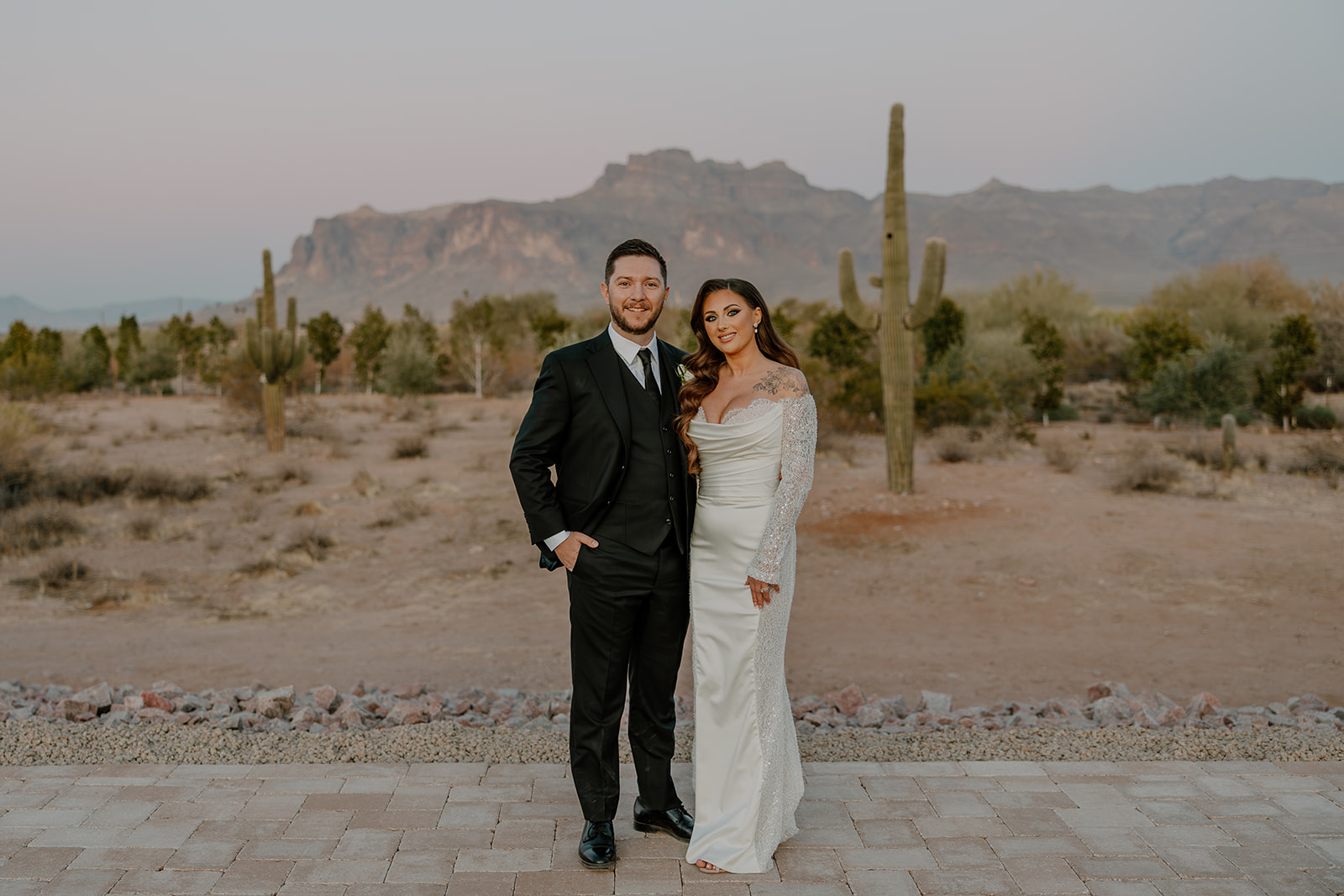 Classic couple shot at sunset with red rock views and saguaro cactus — timeless imagery for your wedding planning guide.