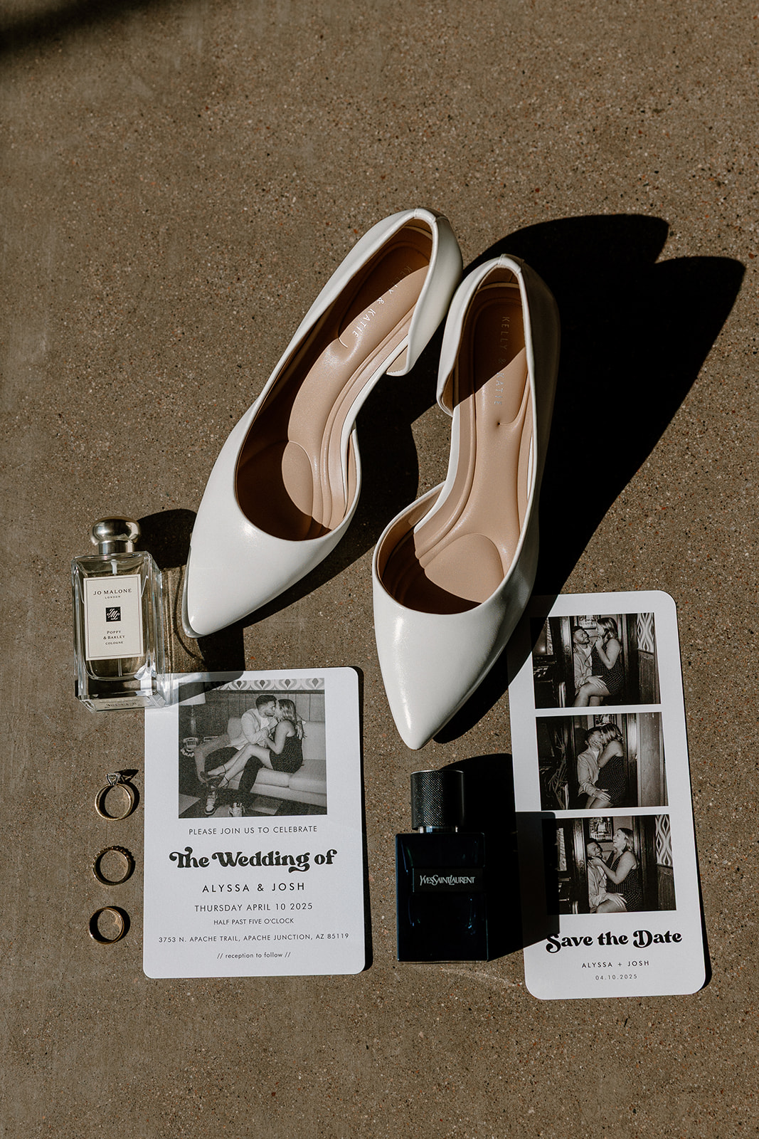 Flat lay of wedding day details, including white heels, perfume, rings, and printed invites with a vintage photo strip.