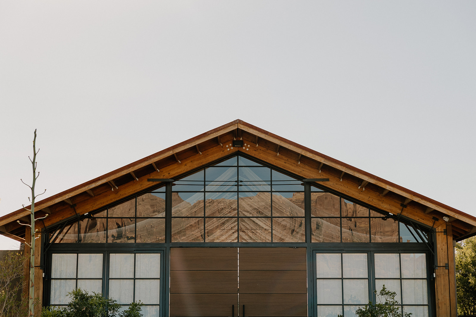 Exterior view of The Paseo wedding venue’s modern barn facade reflecting the Superstition Mountains.