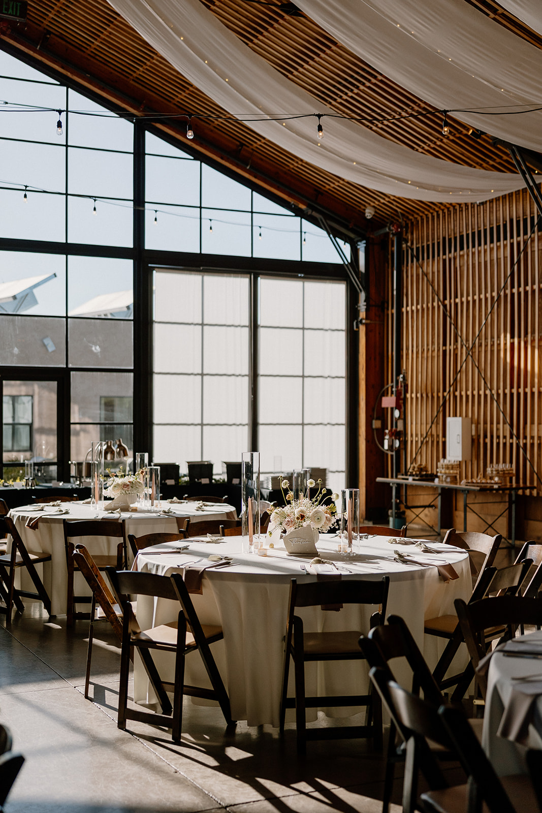Reception table setup at The Paseo wedding venue with neutral linens, soft lighting, and modern architecture in the background.