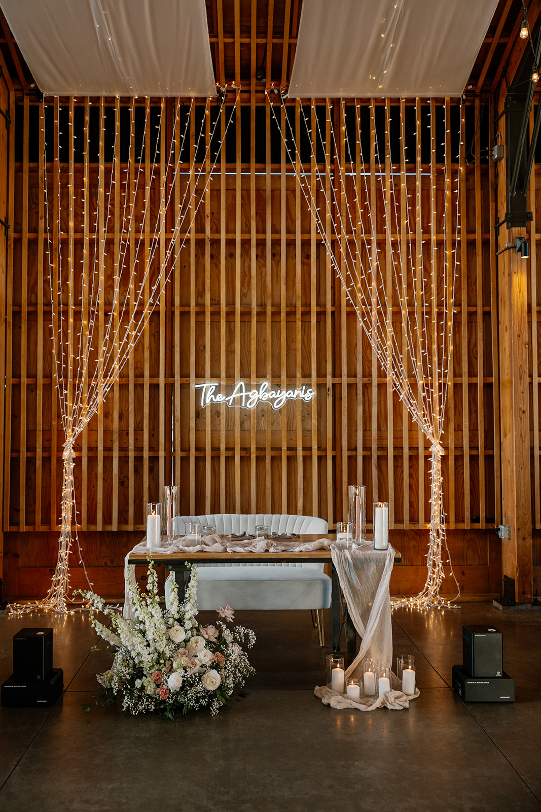 Sweetheart table at The Paseo wedding reception with fairy lights, candles, and custom neon signage.