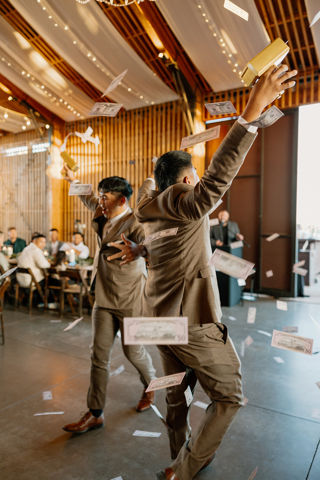 Groomsmen making it rain with money guns during a lively moment at The Paseo wedding reception.