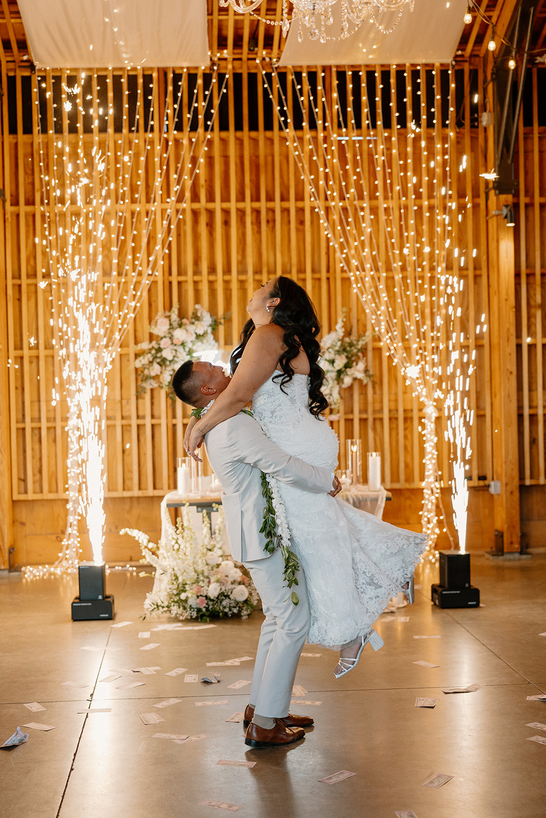 The groom lifting the bride mid-spin under sparklers during their first dance at The Paseo wedding.