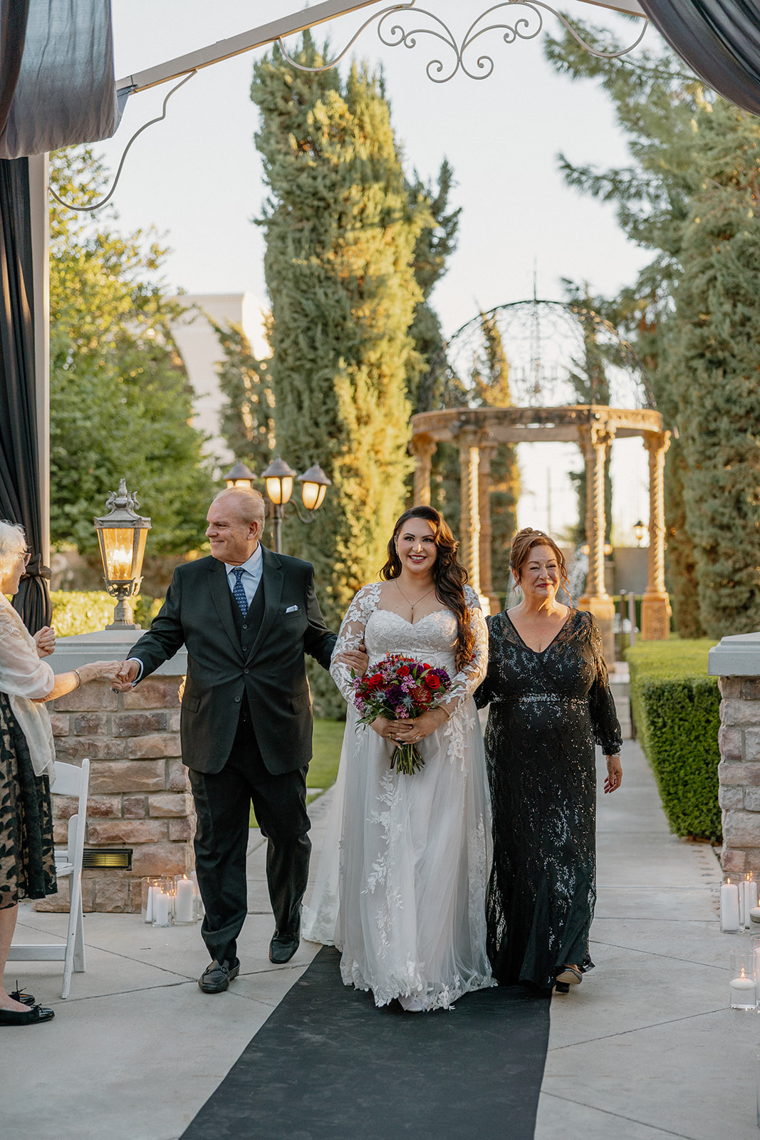 Bride walking down the aisle with her father during an outdoor ceremony at this wedding venue in Chandler.