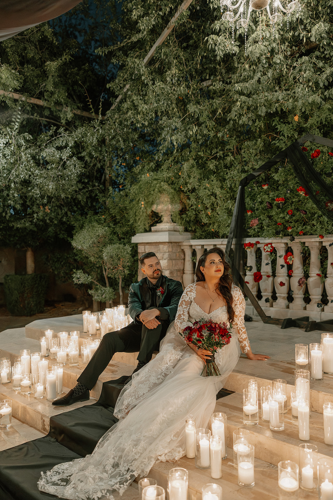 Bride and groom seated on candlelit steps during their reception at a wedding venue in Chandler.