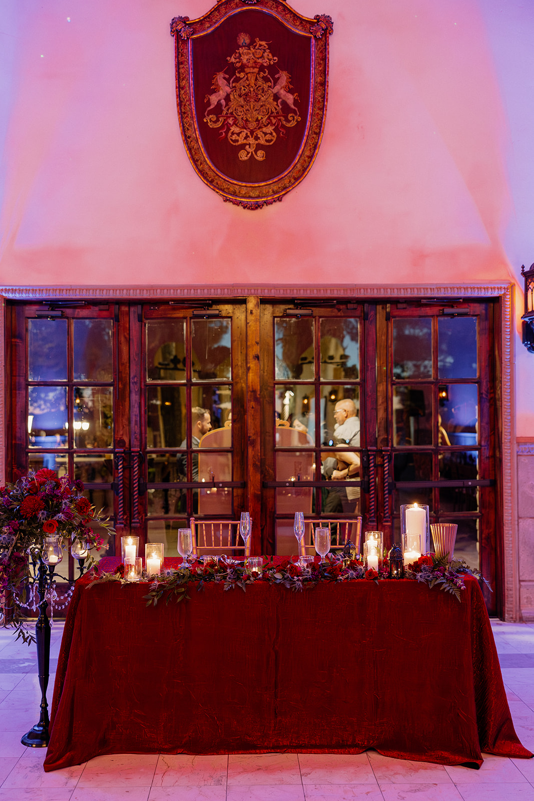 Candlelit sweetheart table with red florals at a wedding venue in Chandler.