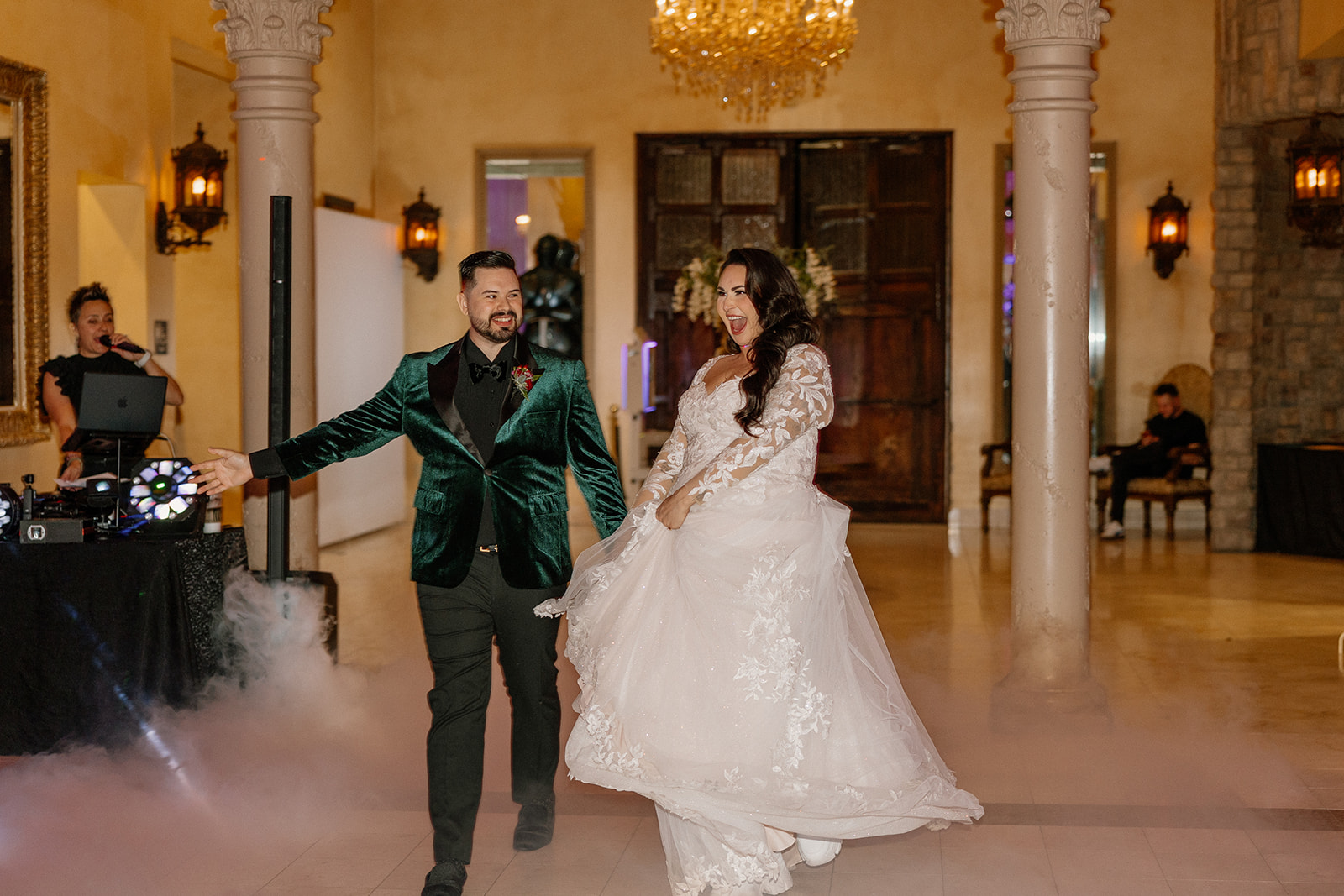 Bride and groom making their reception entrance with low fog and chandelier lighting inside this wedding venue in Chandler.