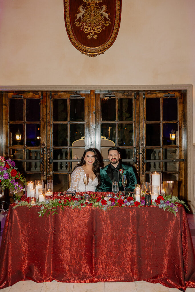 Bride and groom seated at a candlelit sweetheart table at a wedding venue in Chandler.