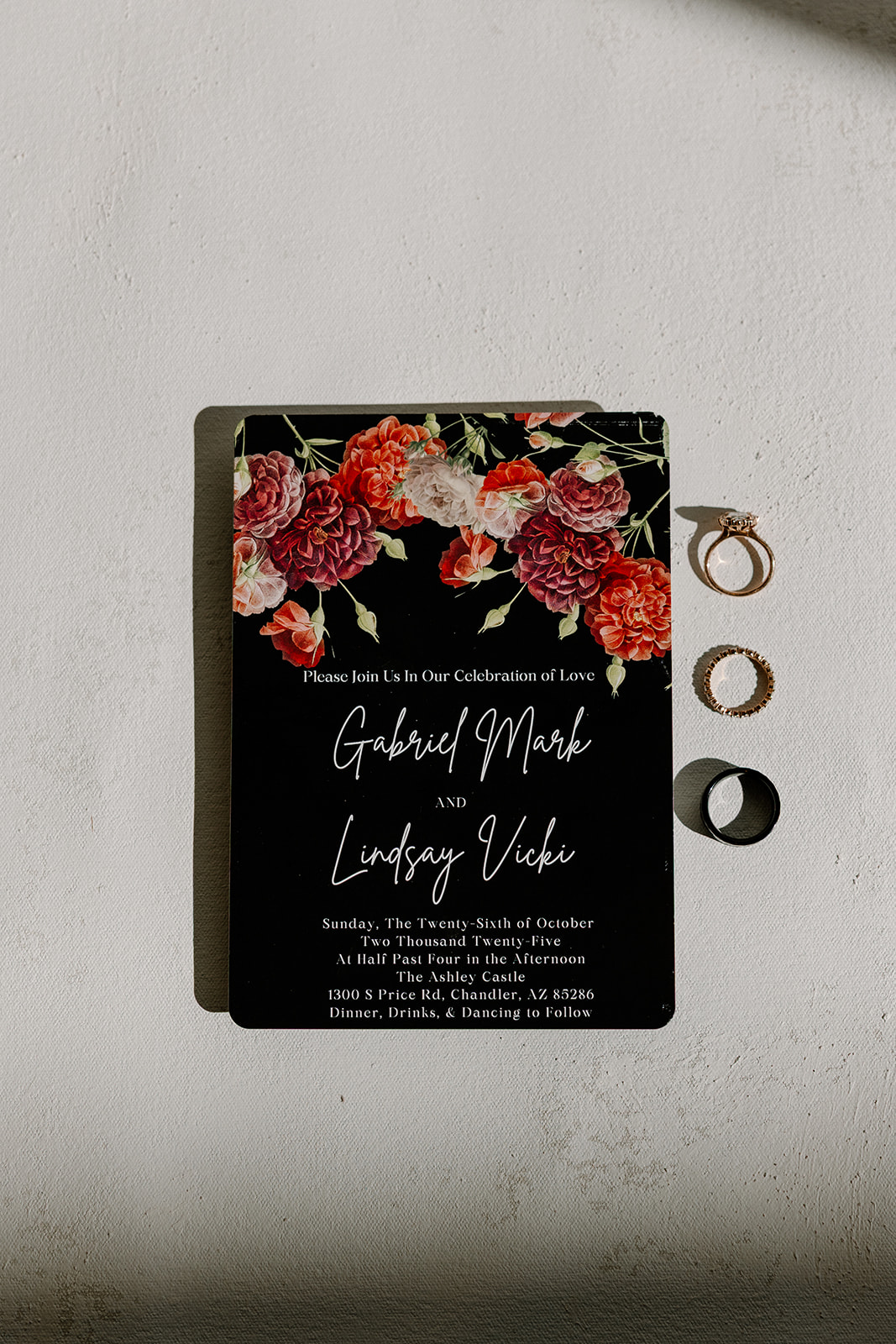 Moody floral wedding invitation suite and rings photographed at a wedding venue in Chandler.