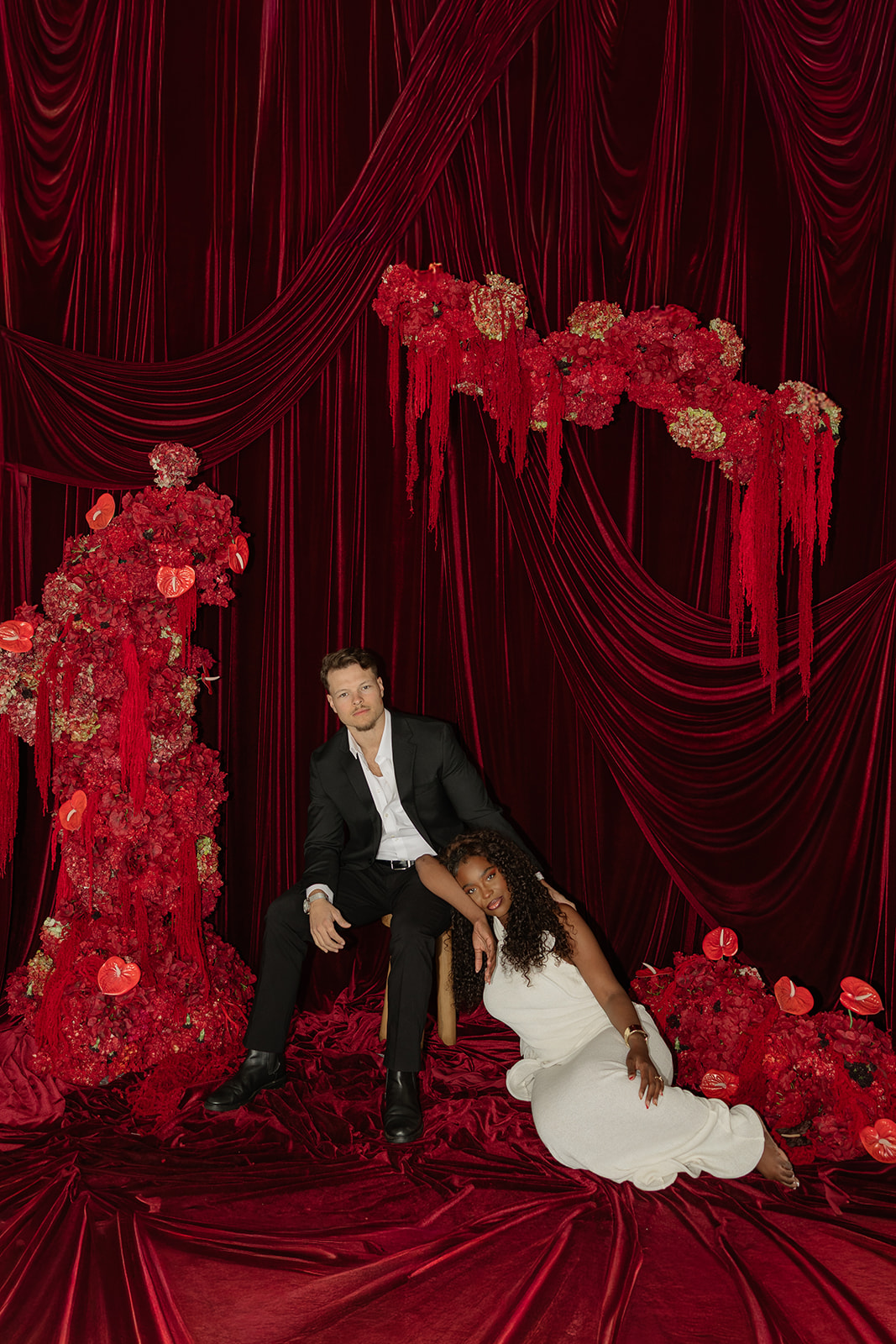 Woman leaning against man in an intimate moment captured during editorial engagement photos in private studio. 