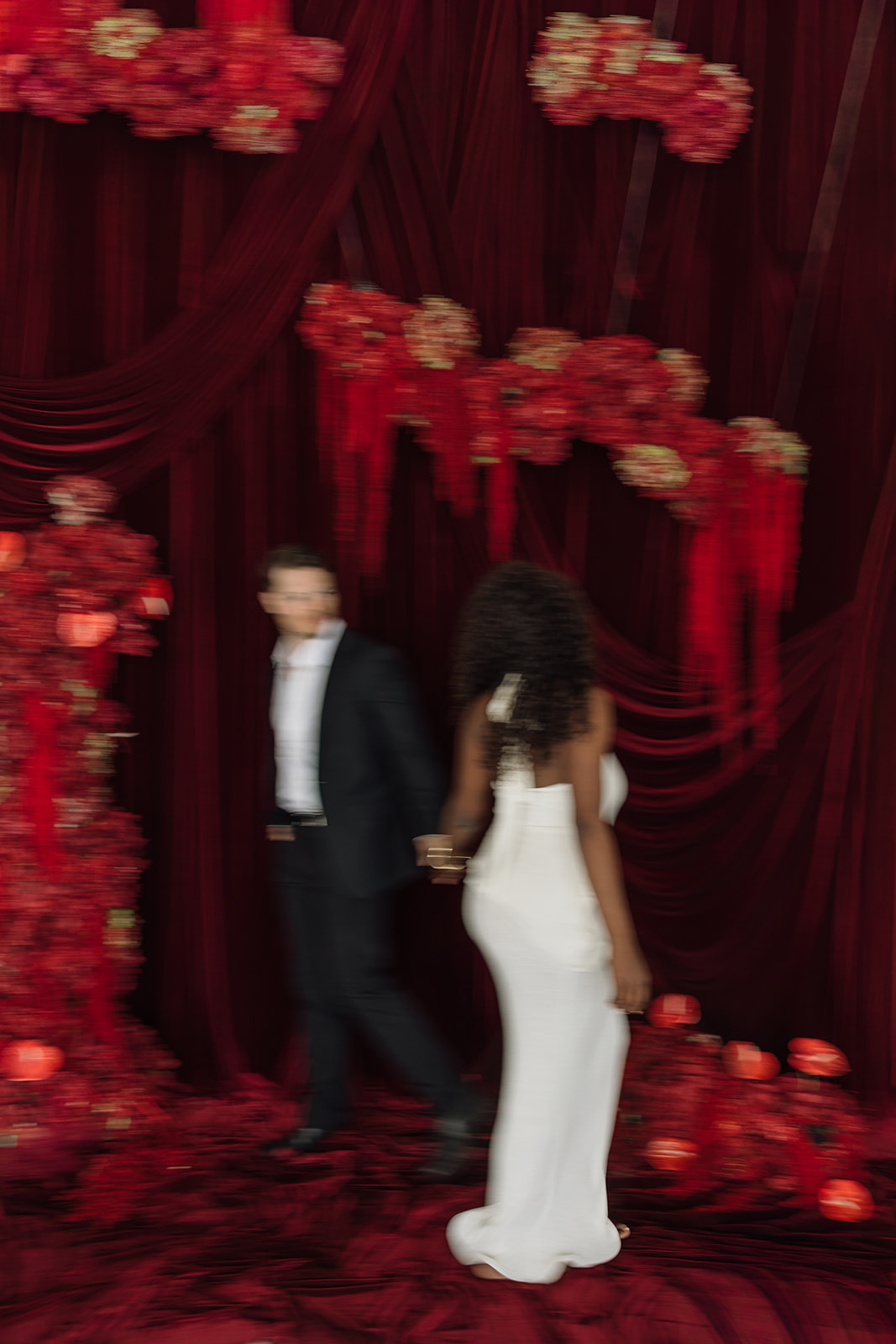 Soft motion photo of couple holding hands and dancing together during editorial engagement photos. 