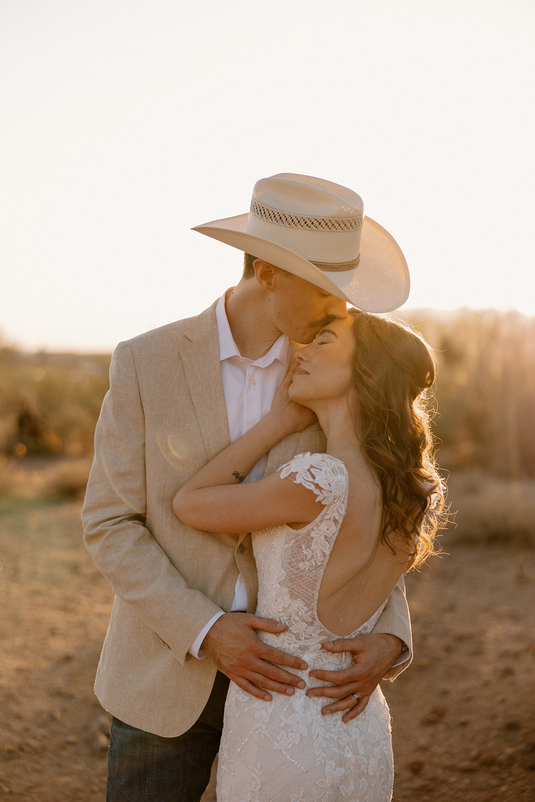 Bride and groom embracing at sunset in the Arizona desert after they elope in Arizona.